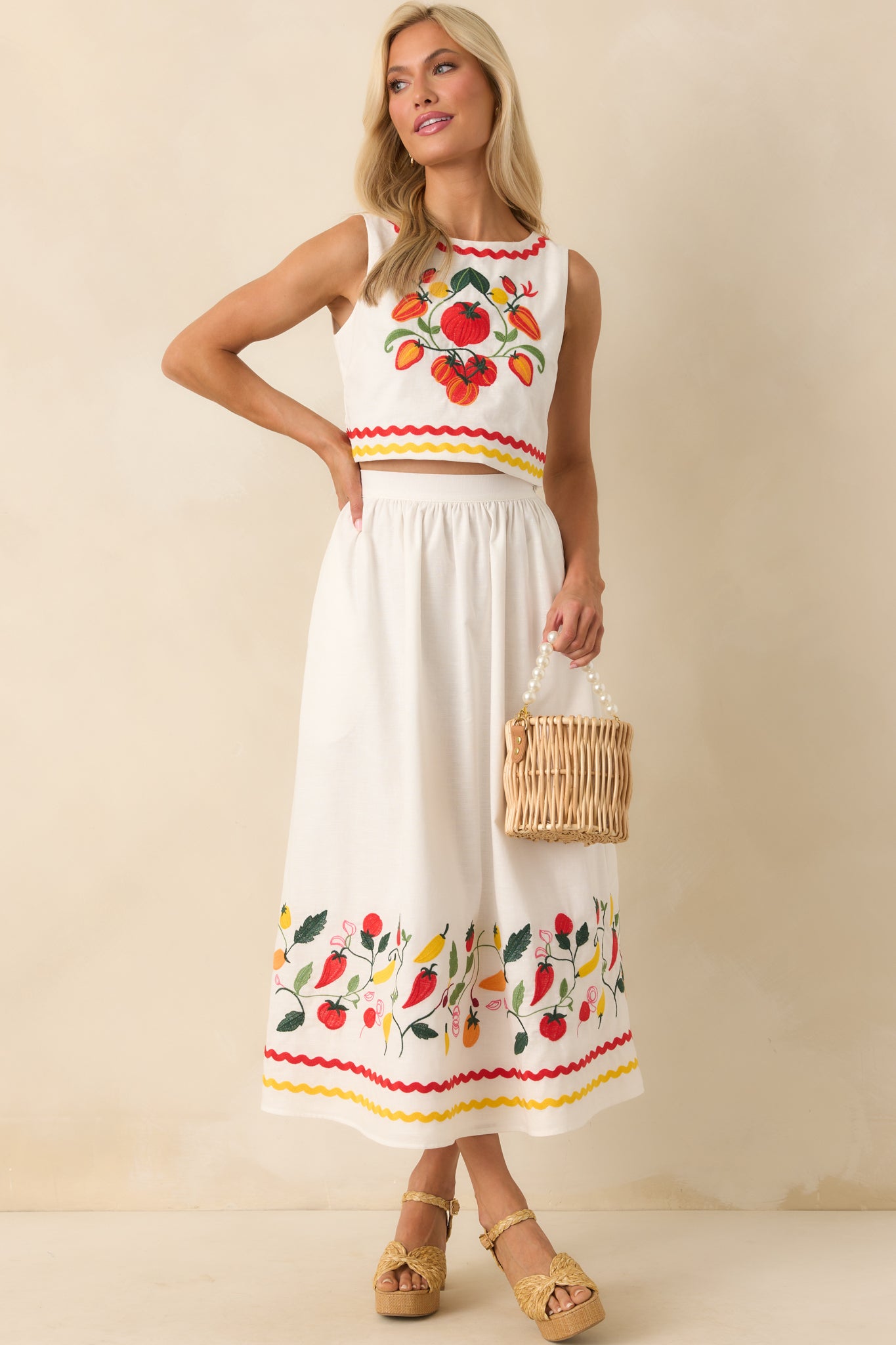 Ivory maxi skirt with colorful vegetable vine embroidery along the hem, shown full-length to display the flowing silhouette.
