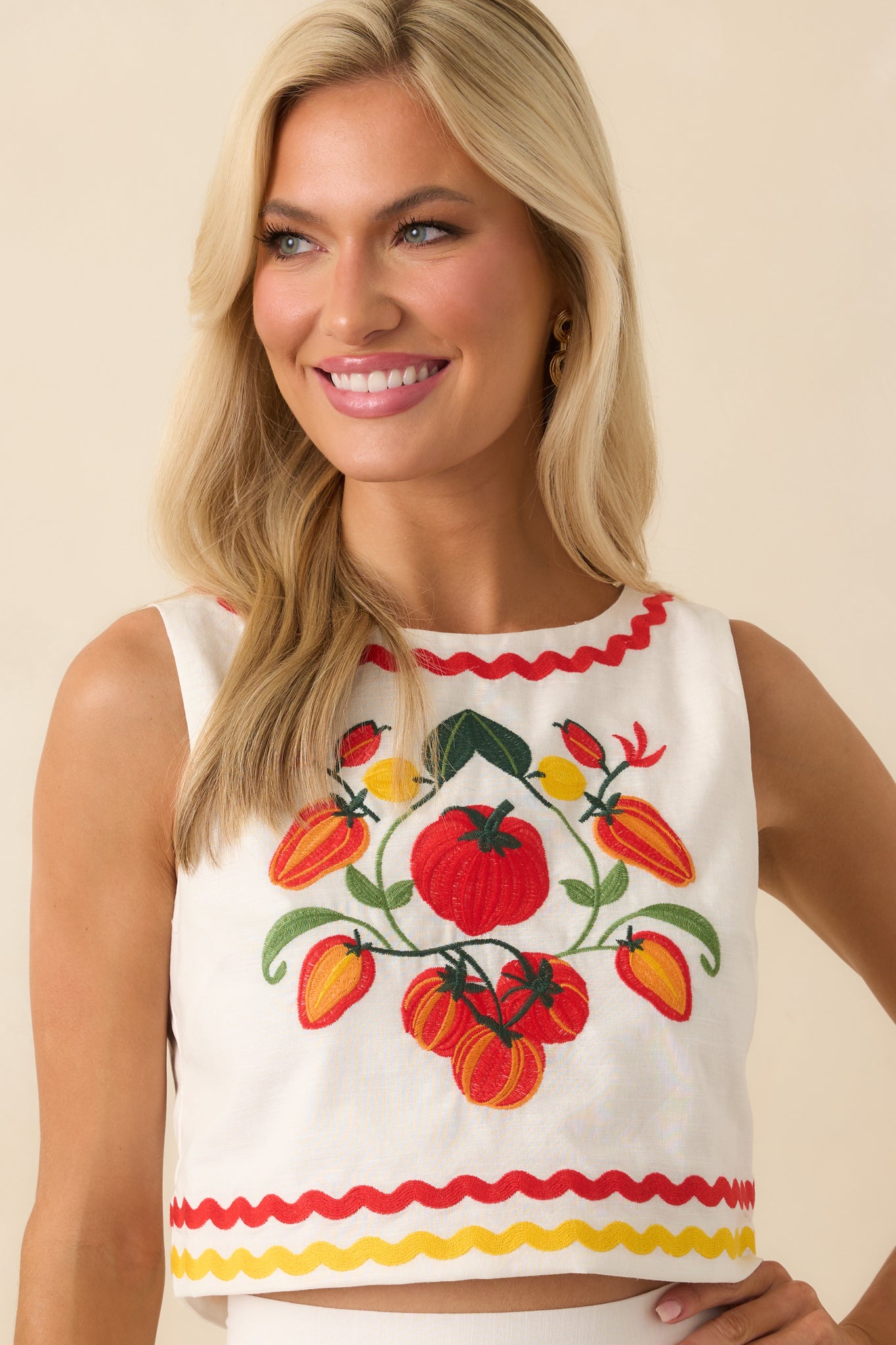 Close-up of the round neckline showcasing red ric rac trim and embroidery near the collarbone.