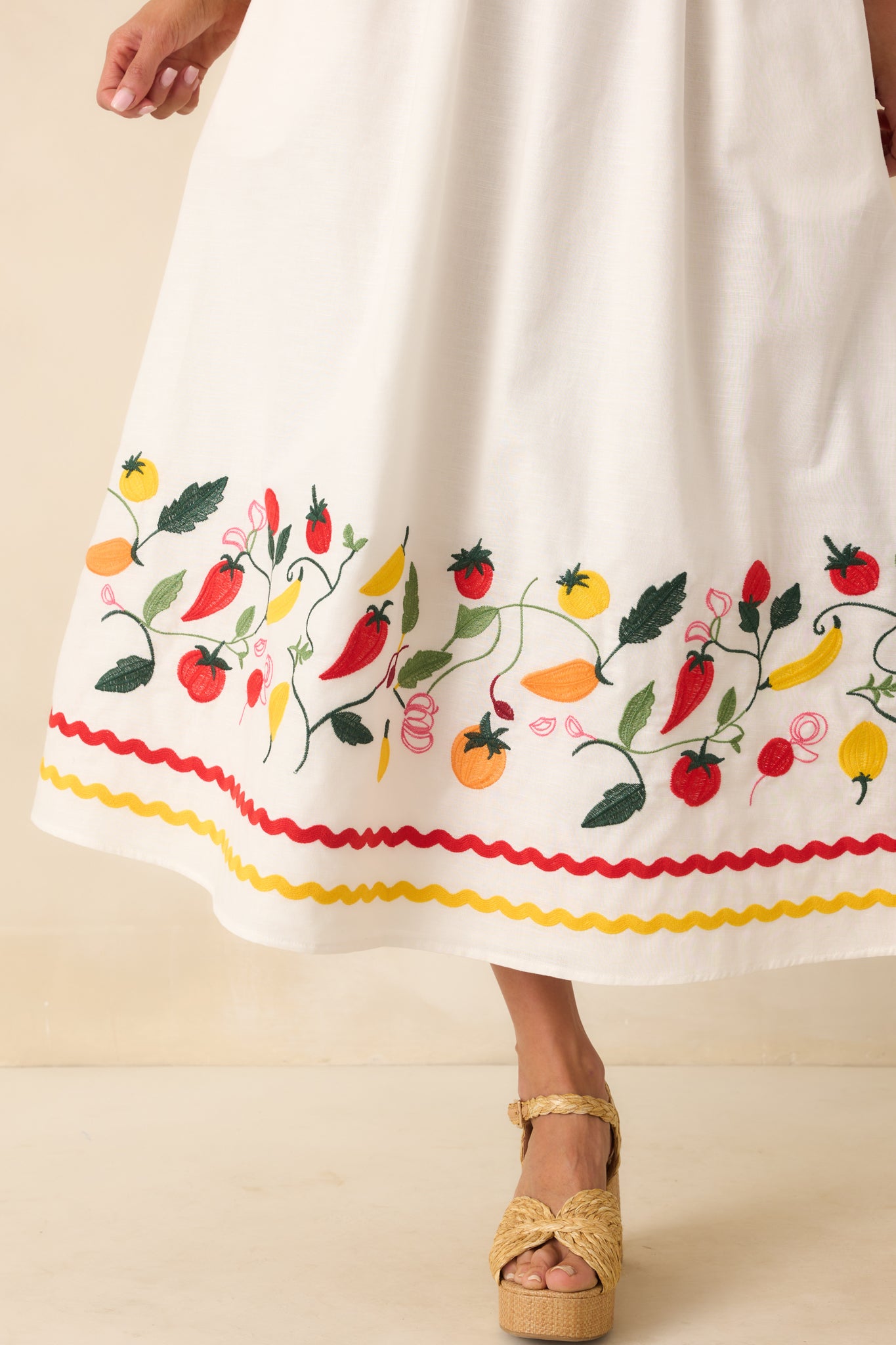 Extreme close-up of the multicolor embroidery and ric rac stitching, revealing intricate threadwork and fabric weave.