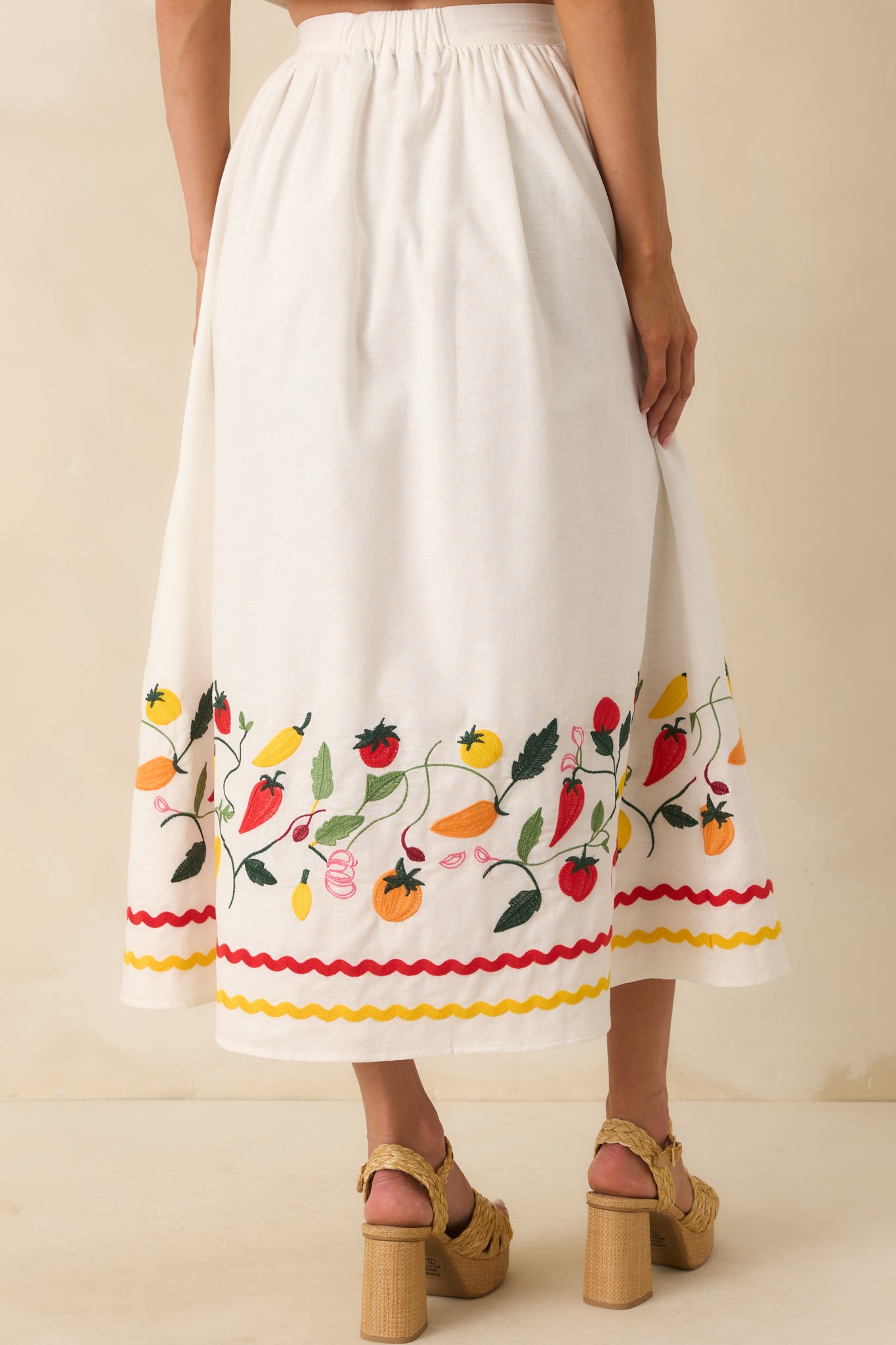 View from behind showing the elastic waist insert and continuation of embroidery and ric rac stripes at the hem.