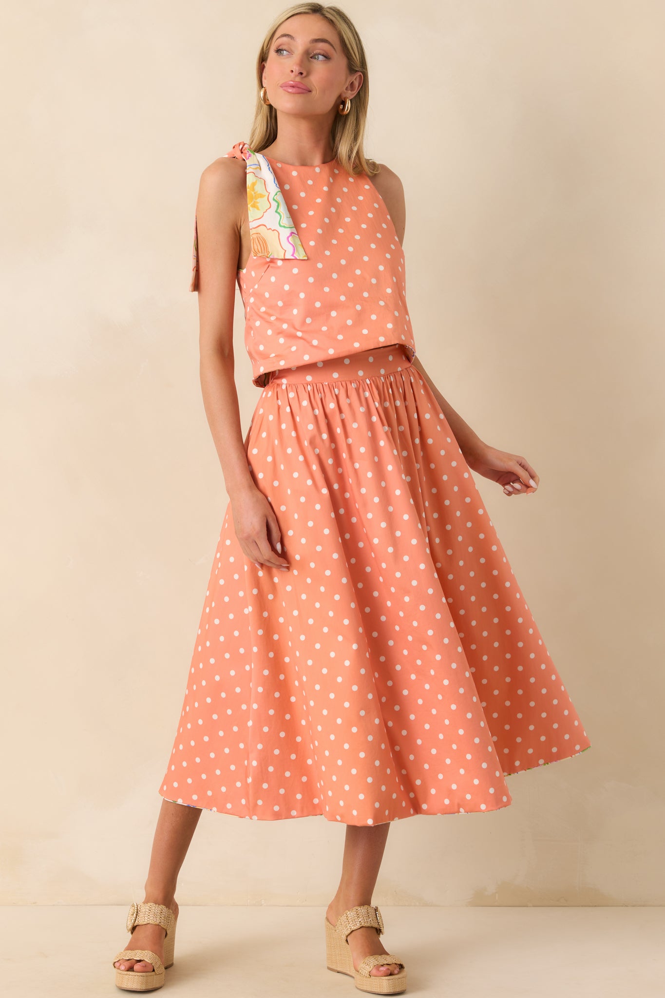 Peach and ivory polka dot midi skirt shown fully, emphasizing fabric texture and silhouette.