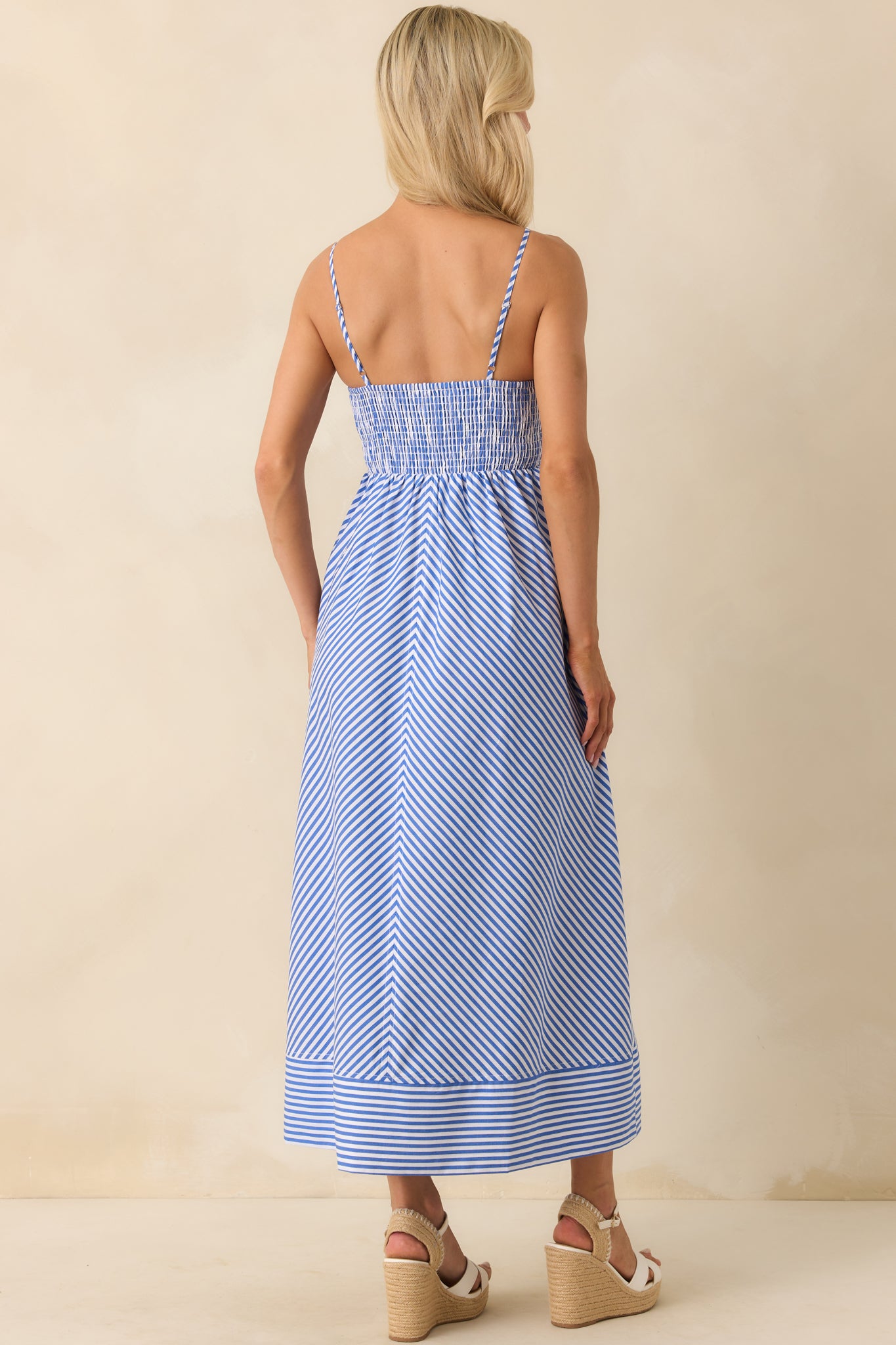 Back view of the blue maxi dress highlighting the smocked back panel and adjustable shoulder straps.