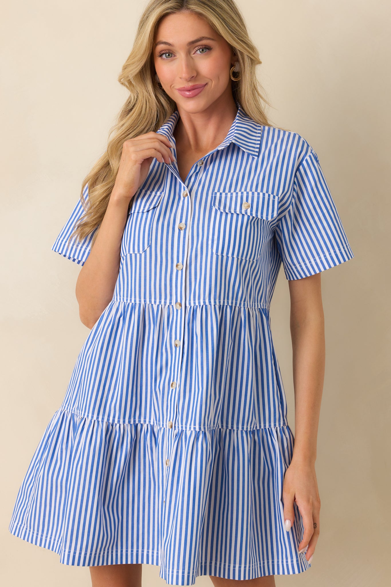 Cropped image focusing on the upper section of the dress, showing the collared neckline and functional breast pockets with button closures.