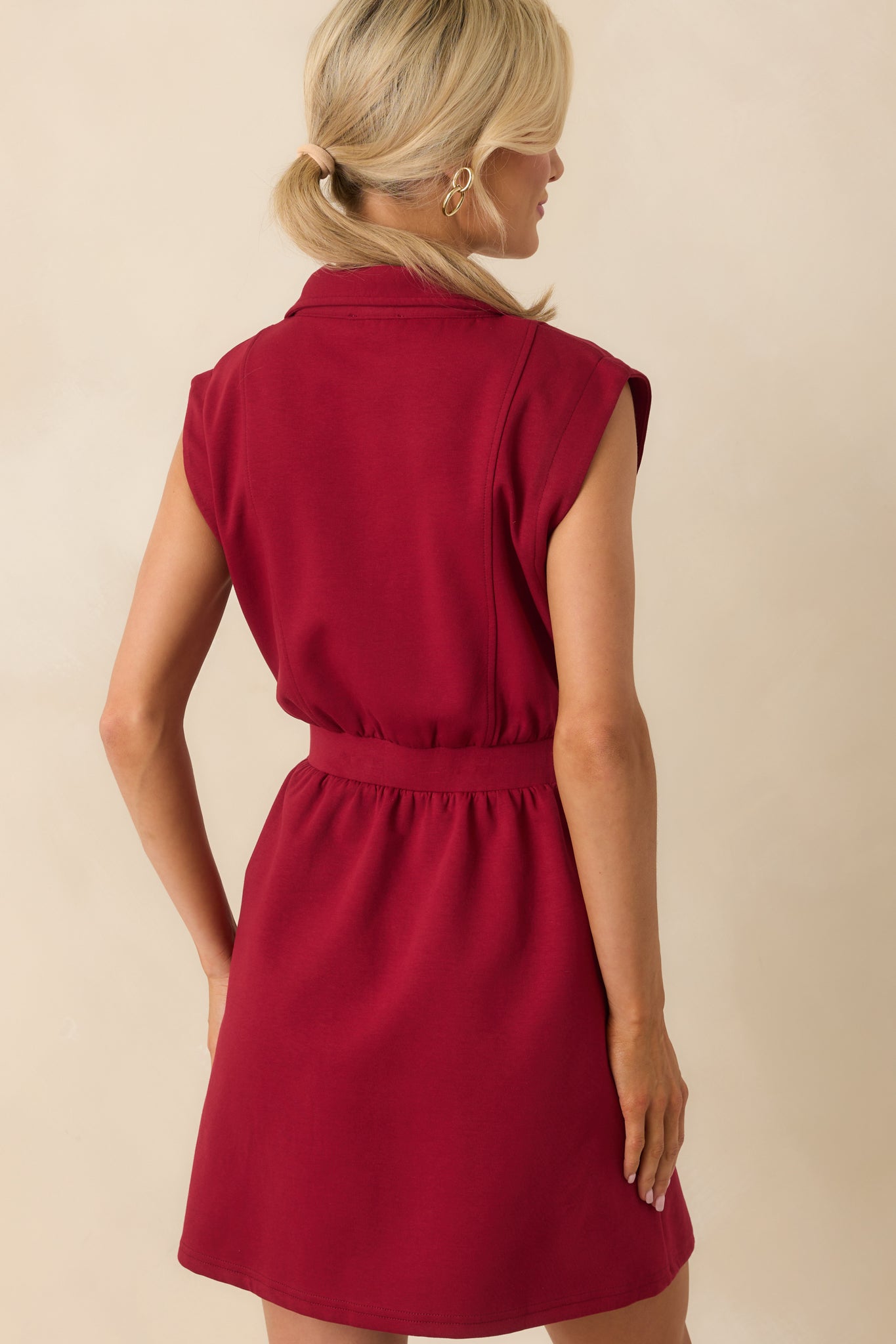 Back view of the burgundy mini dress showing the paneled design and smooth fit over the back.