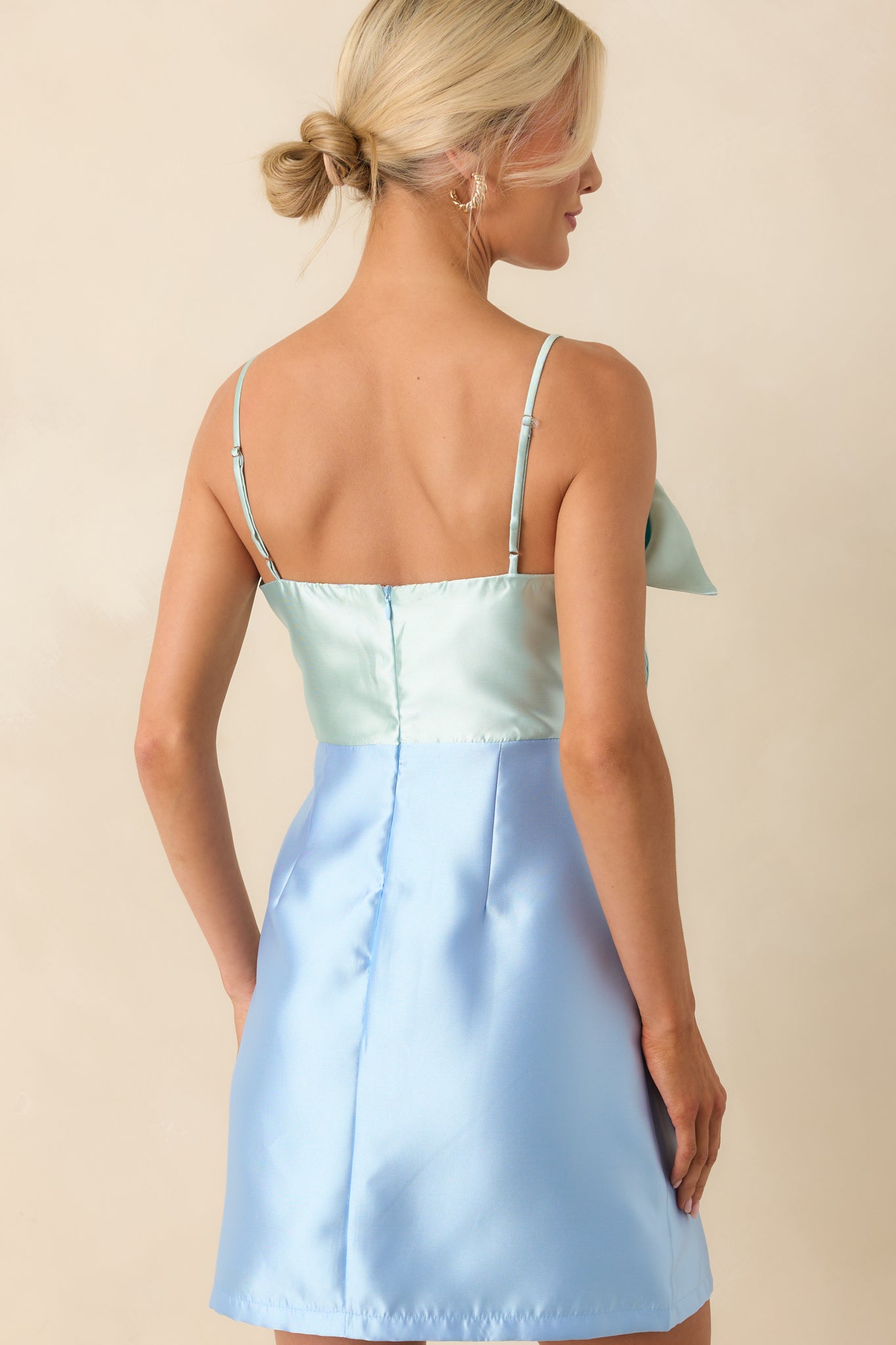 Back view of the mini dress featuring the hidden zipper and adjustable straps, with the mint and light blue tones continuing seamlessly.