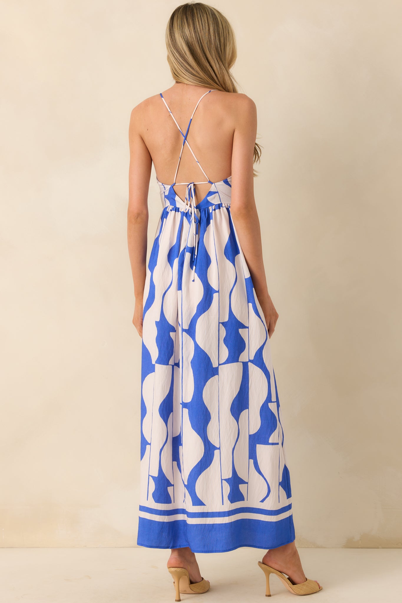 A view from behind showing the adjustable self-tie criss-cross straps, open back design, and hidden back zipper.