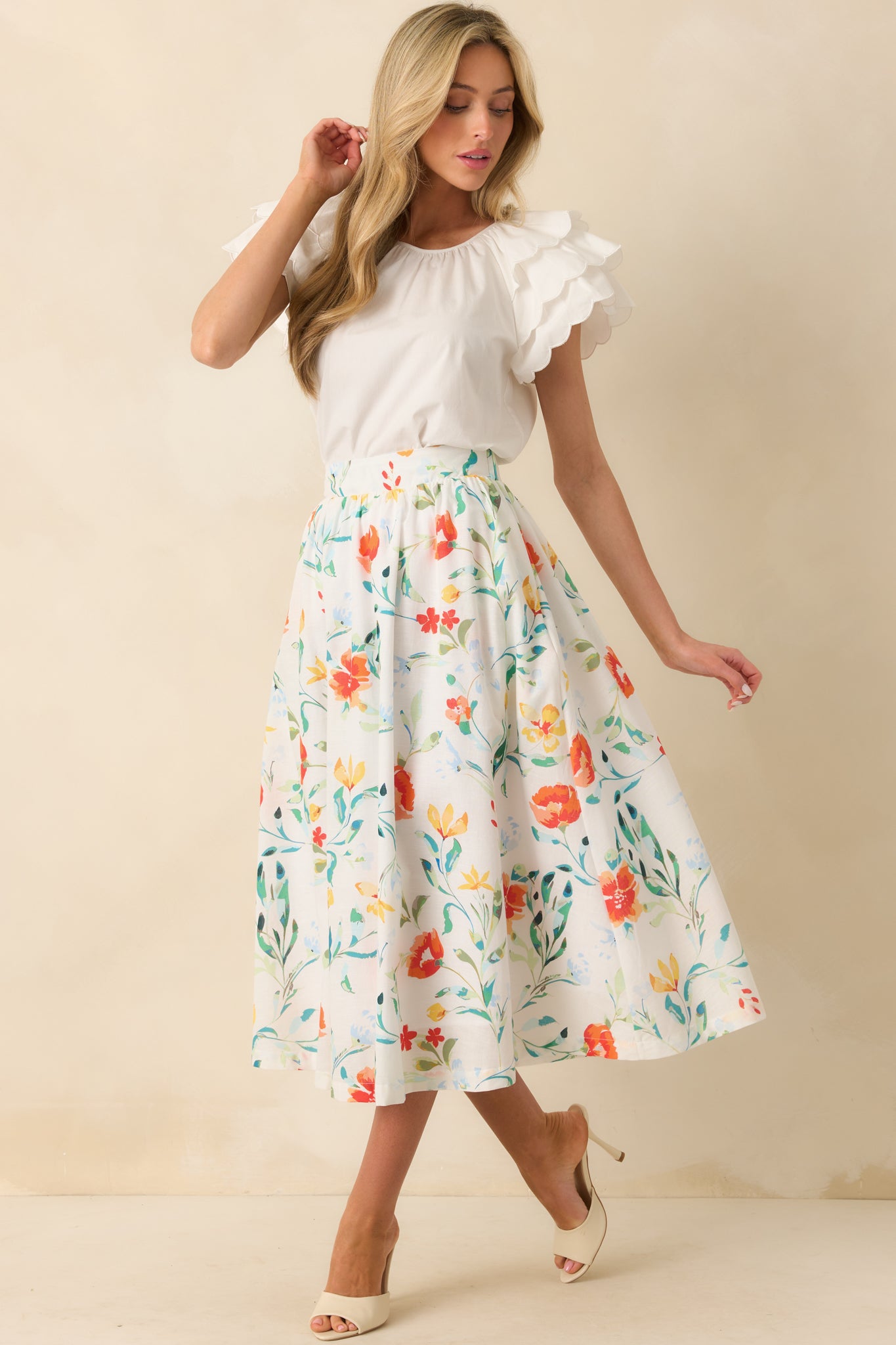 Front view of floral midi skirt featuring a smooth silhouette and subtle pleats over the ivory lining.