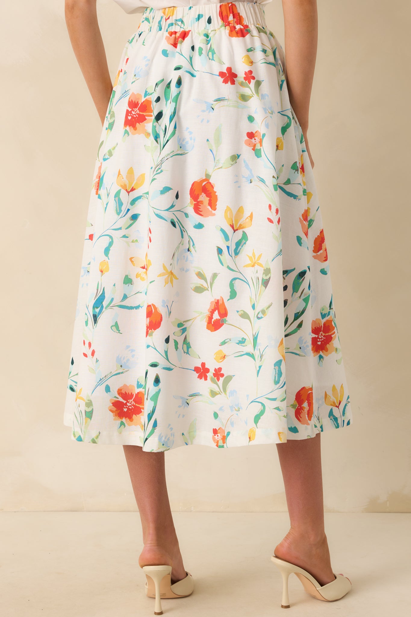View from behind showing the elastic waist insert and continuation of the floral print along the midi skirt.