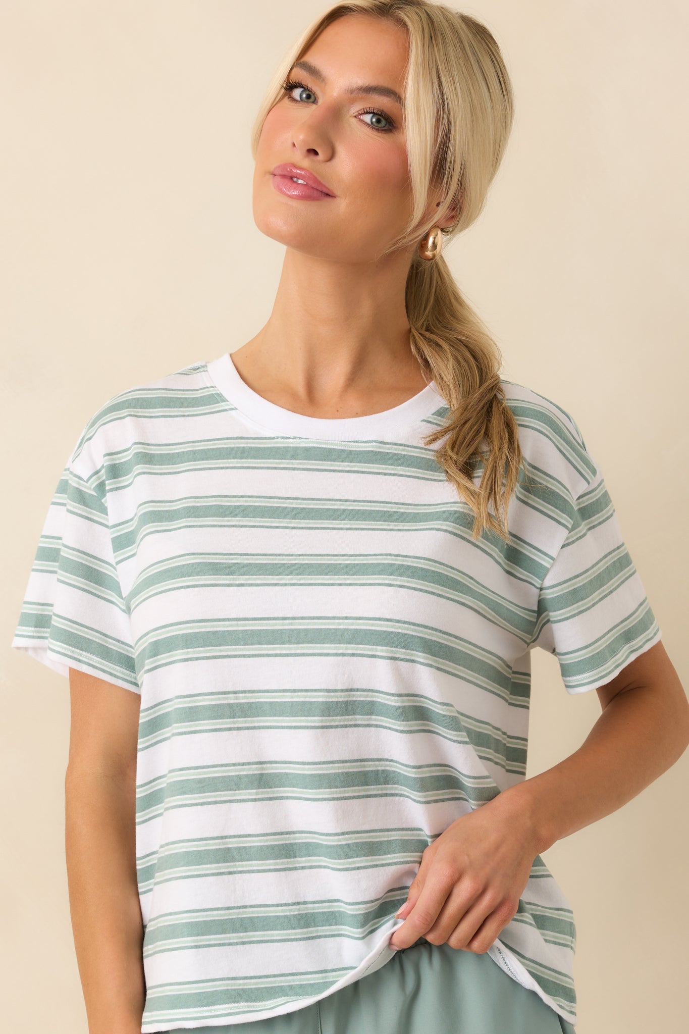 Cropped image of the chest and shoulders, focusing on the crew neckline and stripe alignment.