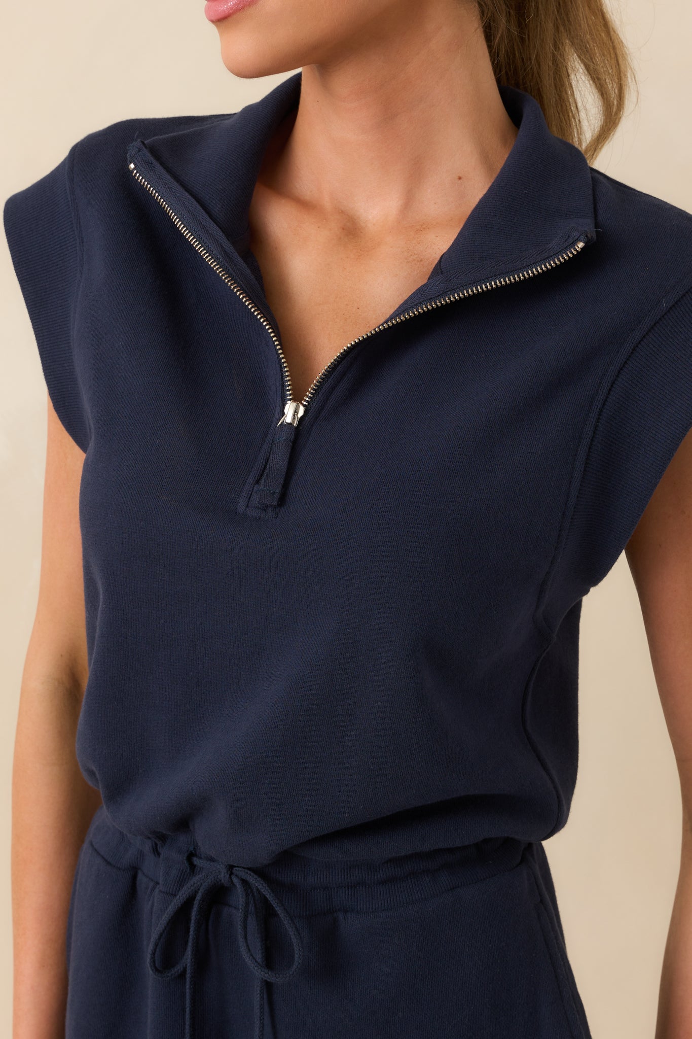 Zoomed-in detail of the fabric around the zipper and collar, showing the stitching and structure of the neckline.
