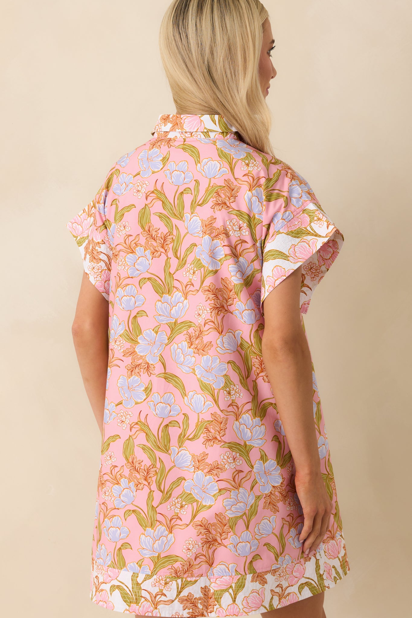 Back view of the mini dress displaying the continuation of the blue floral print and the flow of the relaxed fit from behind.