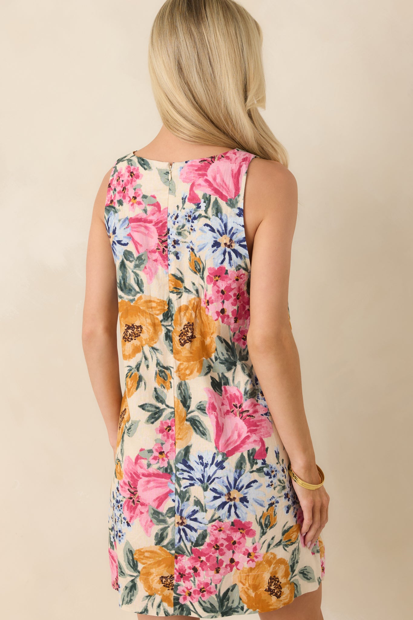Back view of the floral mini dress featuring a sleeveless silhouette, fully lined design, and concealed zipper closure.