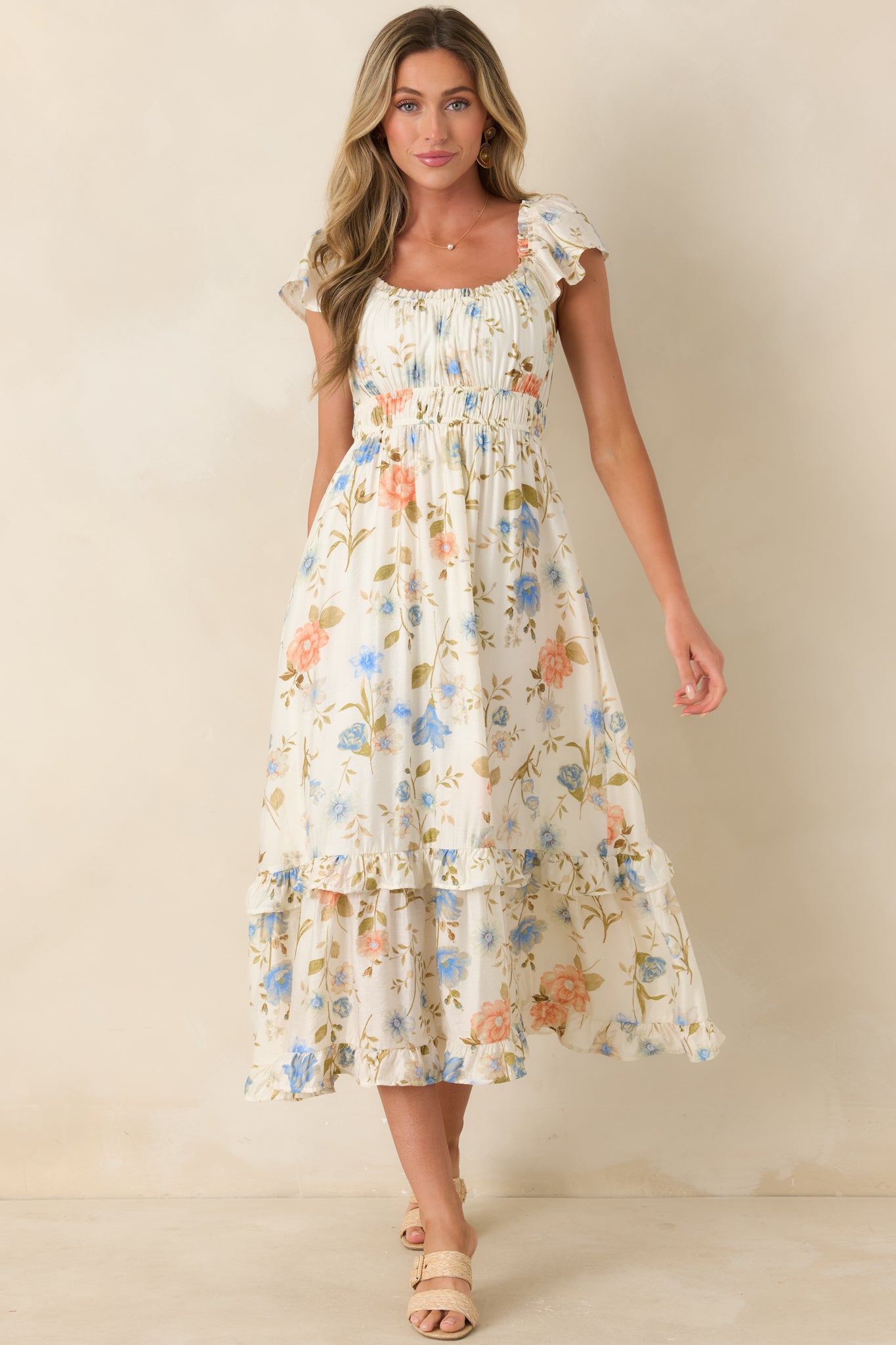 Ivory floral midi dress with flutter sleeves and a flowing, relaxed silhouette.