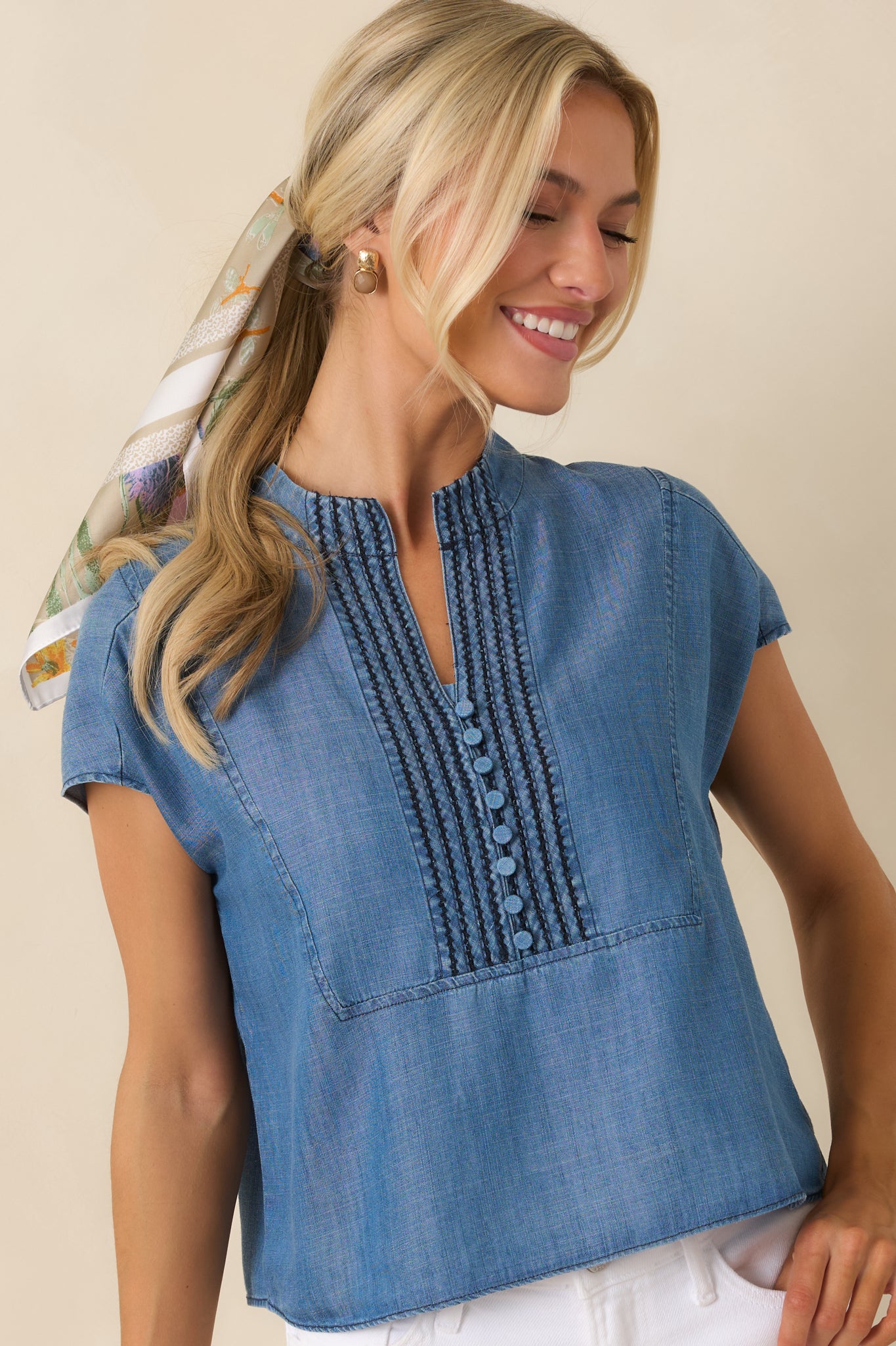 Cropped view of the lightweight top showcasing decorative covered buttons and soft lyocell fabric texture.