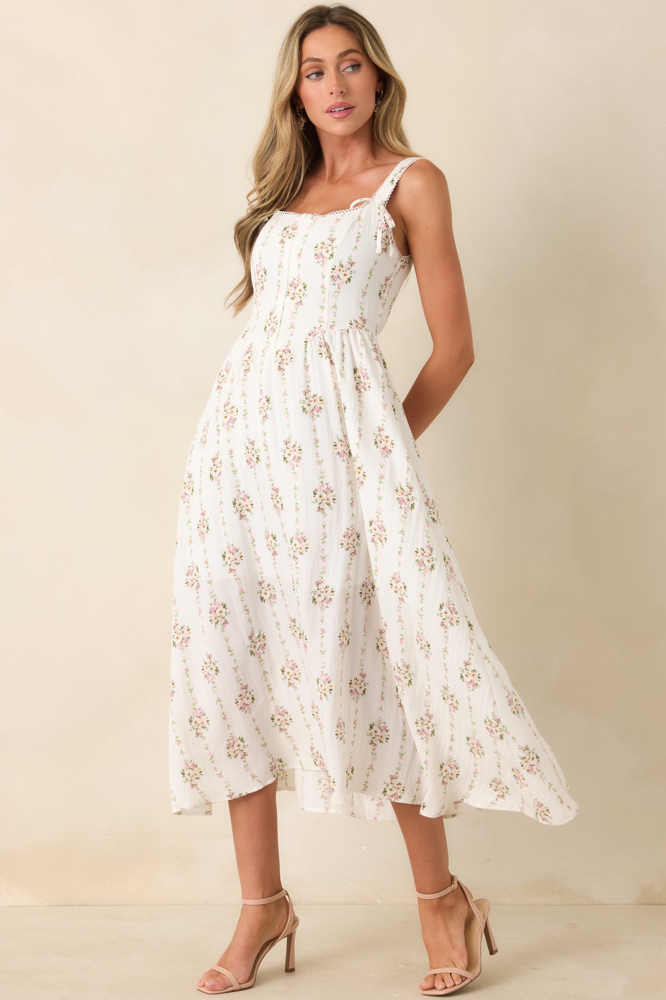 White floral midi dress showcasing a softly tailored shape, hook and eye front detailing, and a flowing midi-length skirt.