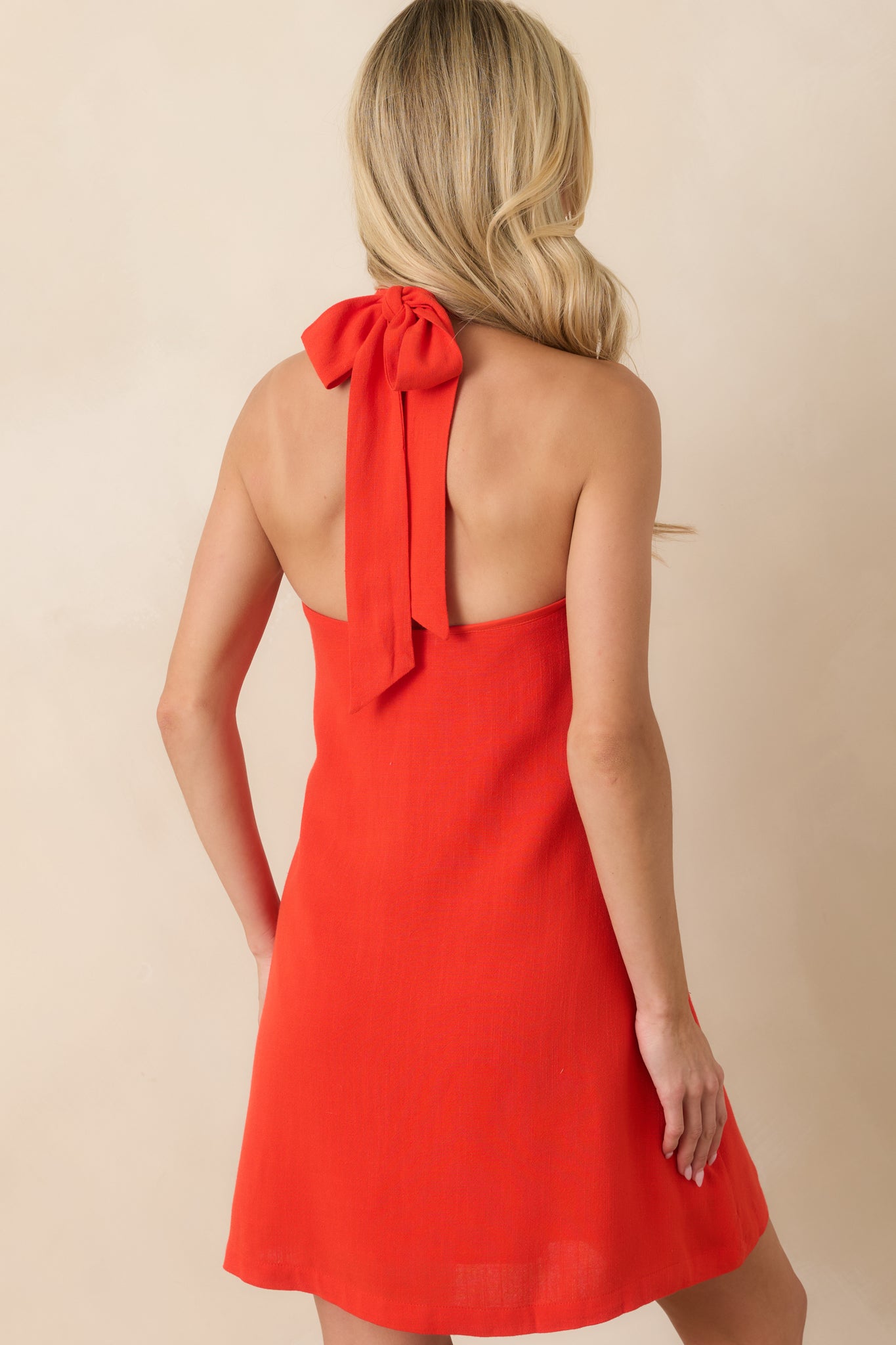 Rear view of the sangria mini dress featuring a relaxed A-line silhouette and clean halter neckline finish.
