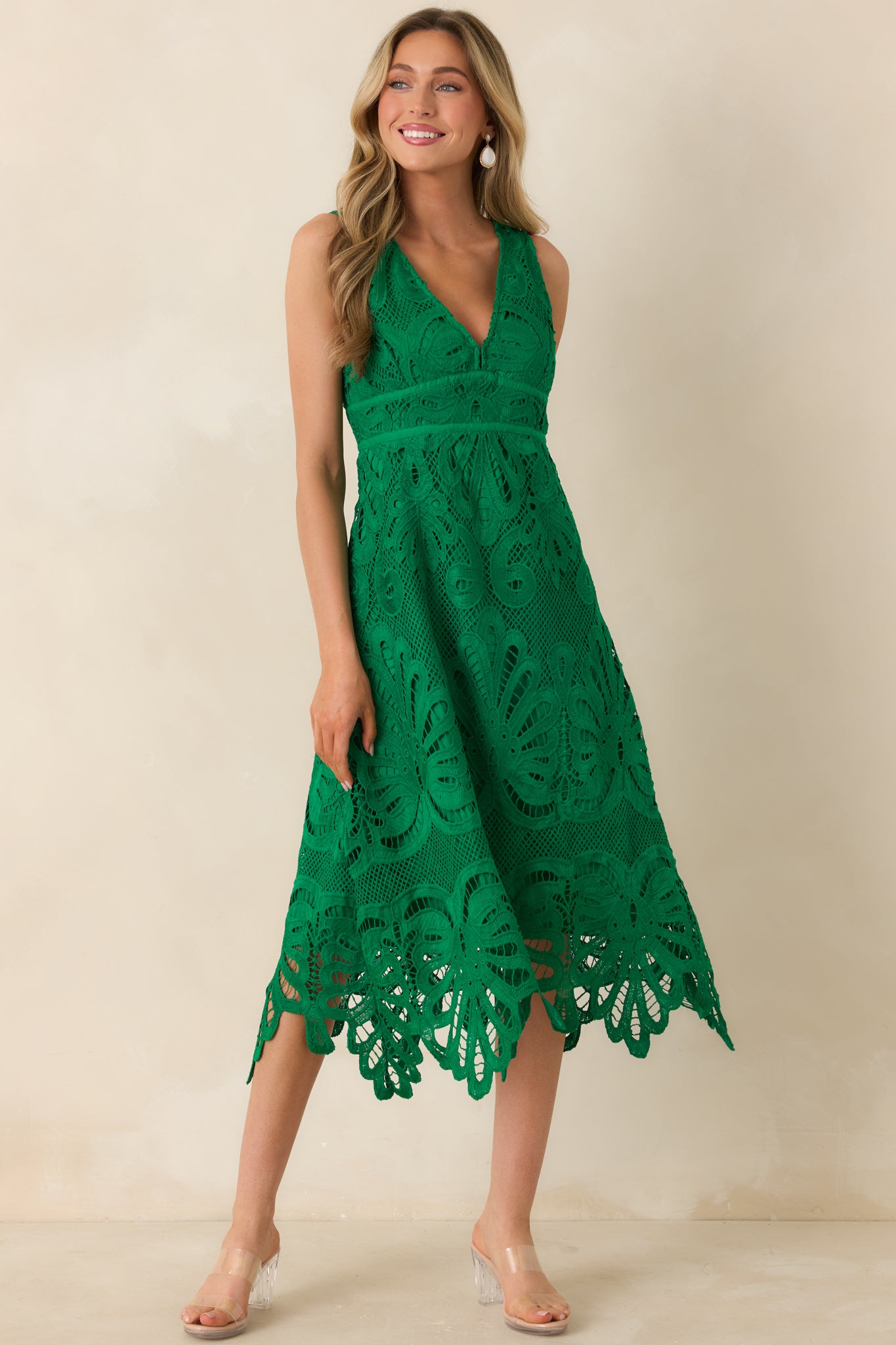Intricate green lace dress featuring a defined waist and flowing midi-length skirt.