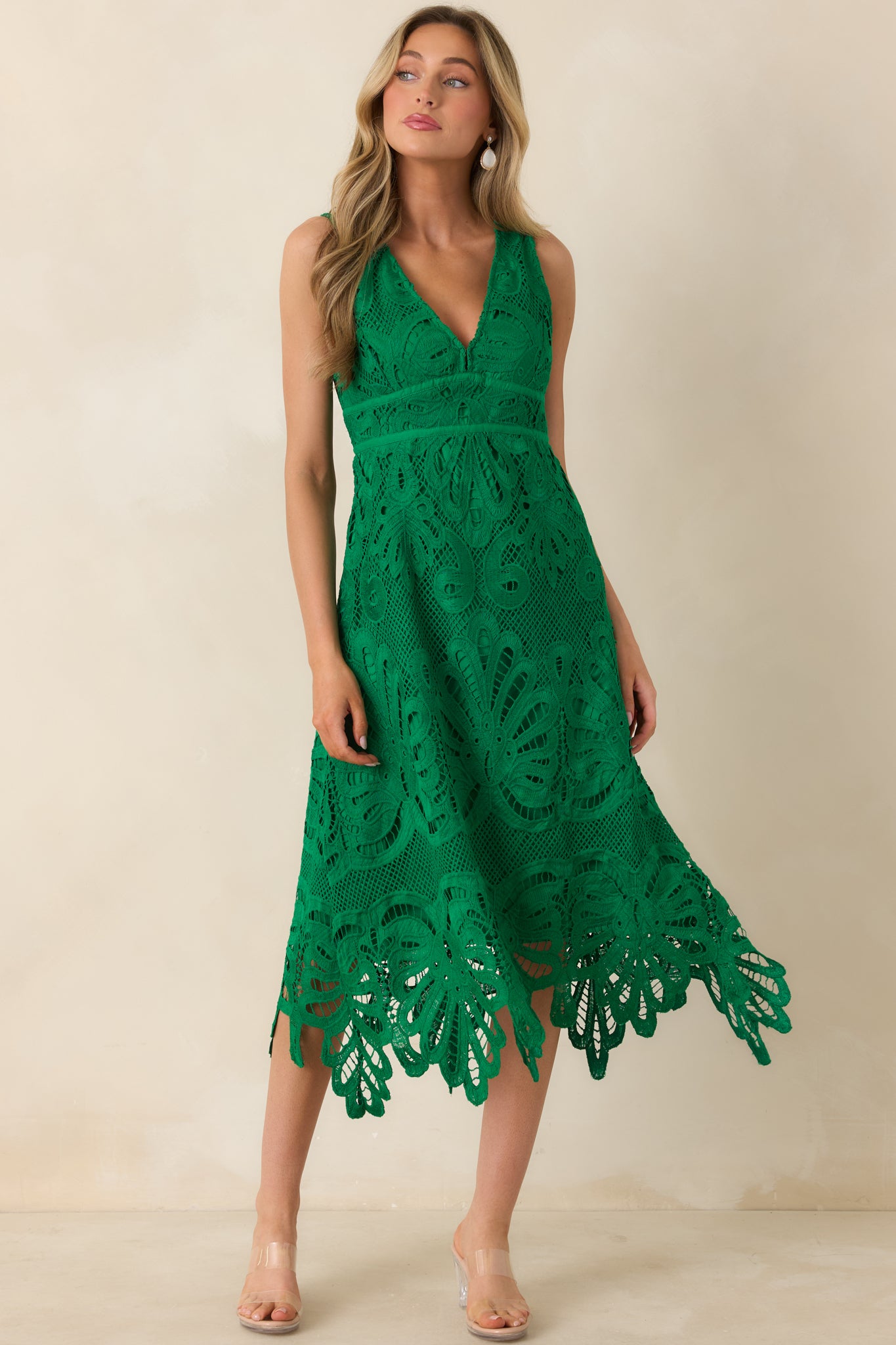 Green lace dress with a fitted waist and graceful midi skirt finished in scalloped lace.