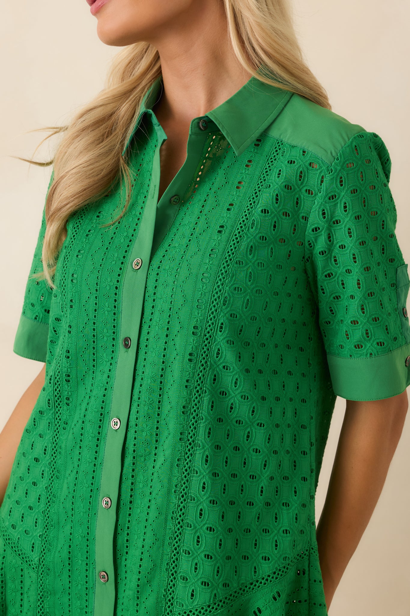 Close-up of the green eyelet fabric highlighting the intricate embroidery texture and button-front detailing with lining beneath.