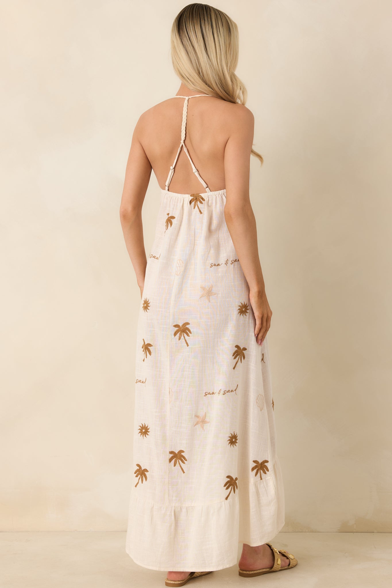 Rear view of light beige gauze midi dress showing thin straps and relaxed fit.