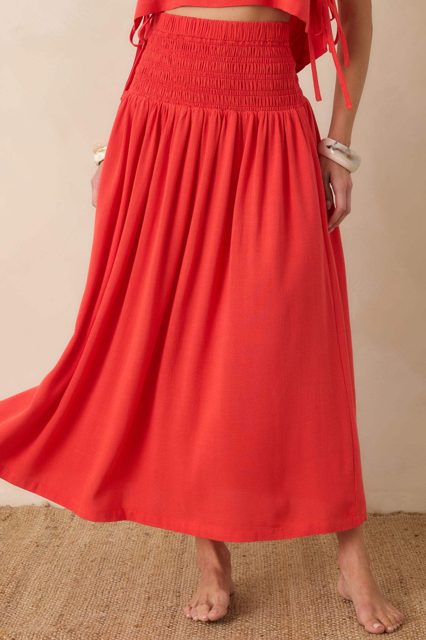 Close look at the lightweight viscose and linen blend fabric with soft gathers flowing into the maxi-length skirt.