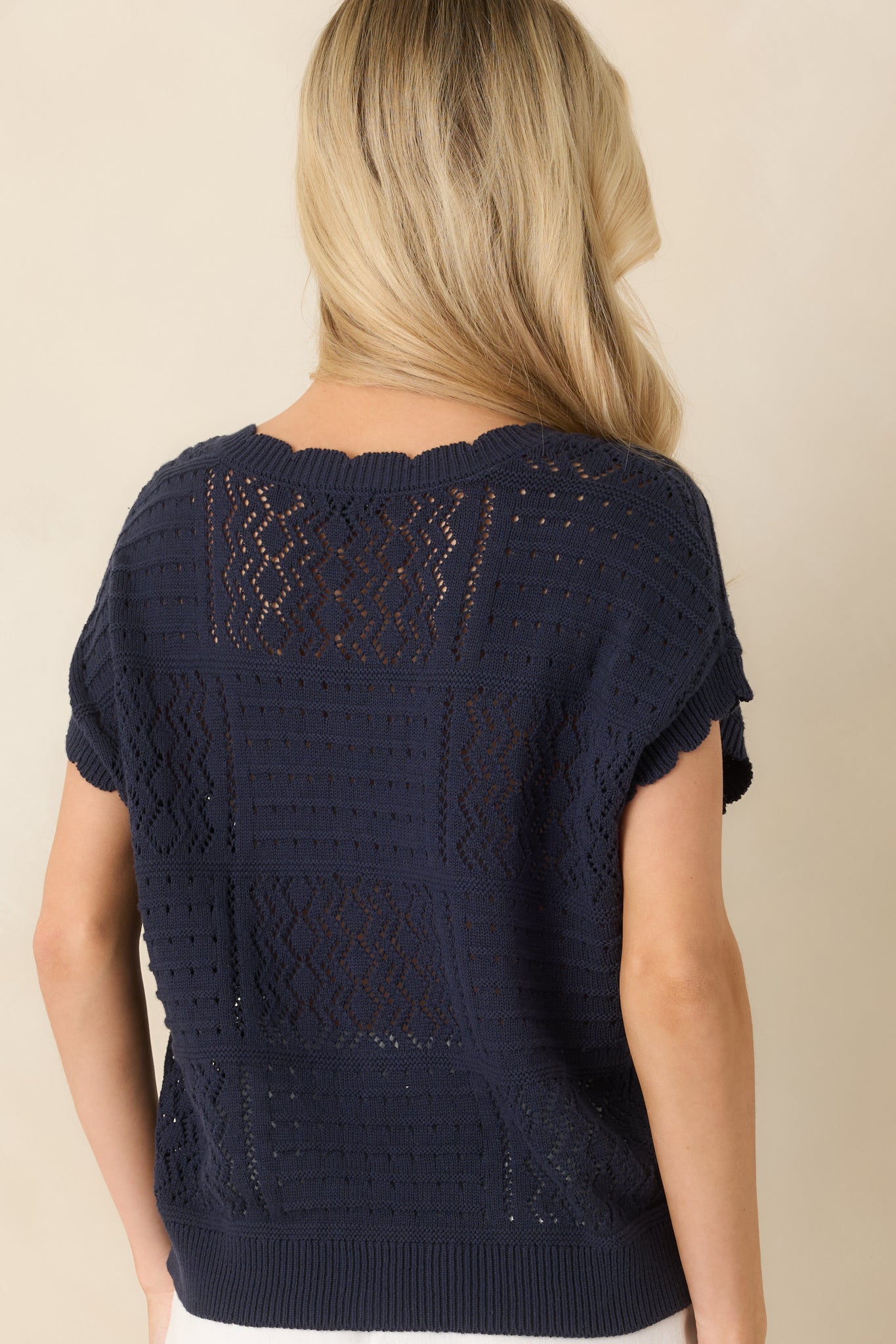 Rear view of open-knit cardigan with collared neckline and relaxed, textured knit design.
