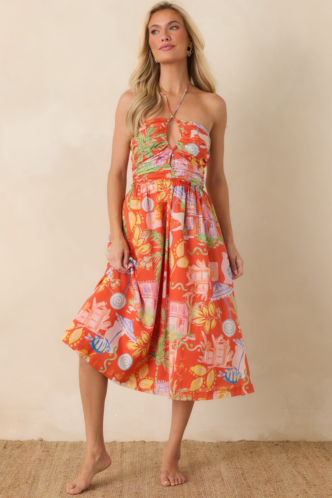 Orange printed midi dress featuring an adjustable halter tie neckline and a flattering, easy-fitting smocked bodice.