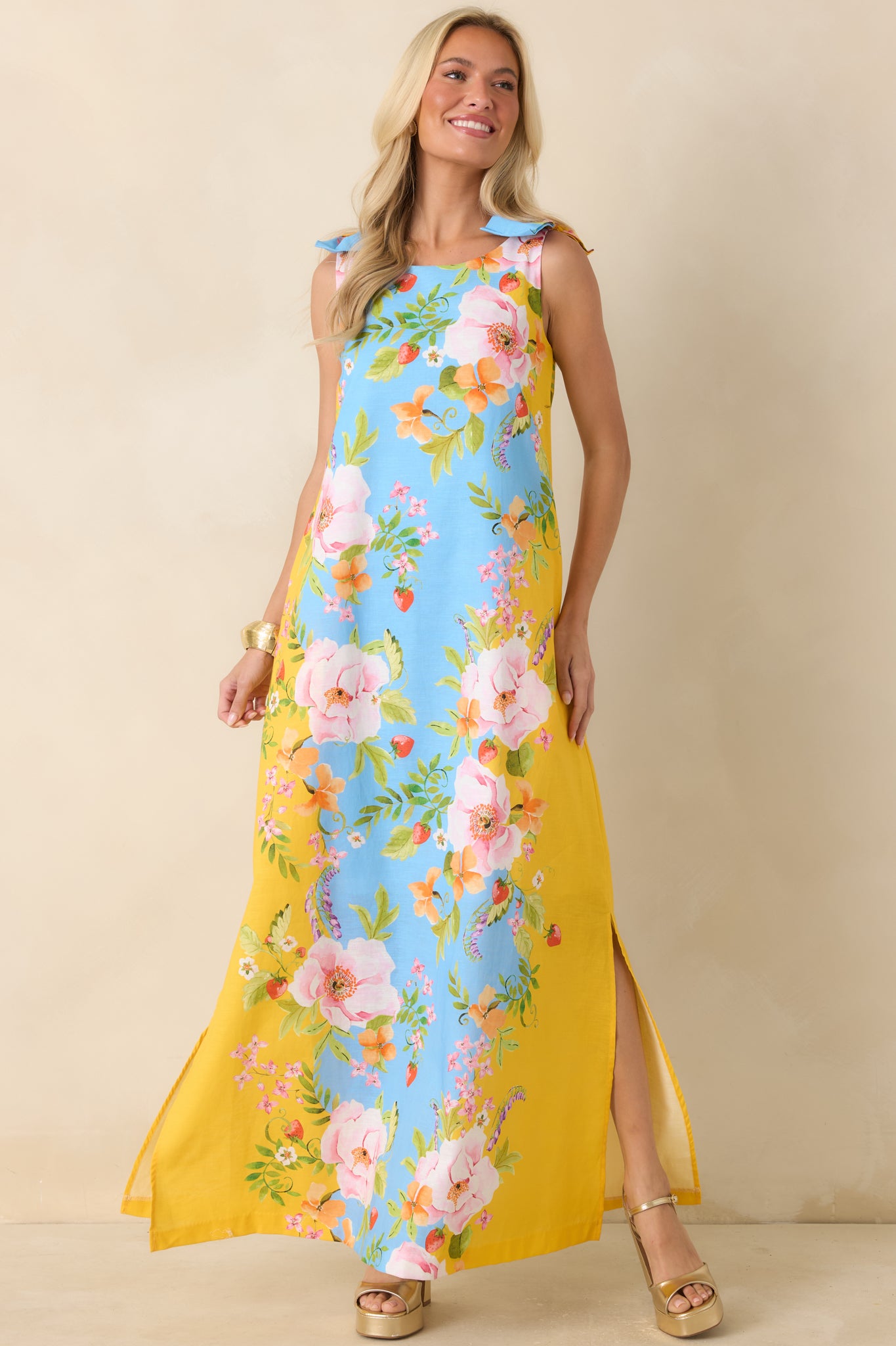Blue and yellow floral dress showcasing a breezy maxi-length silhouette with delicate shoulder tie details.