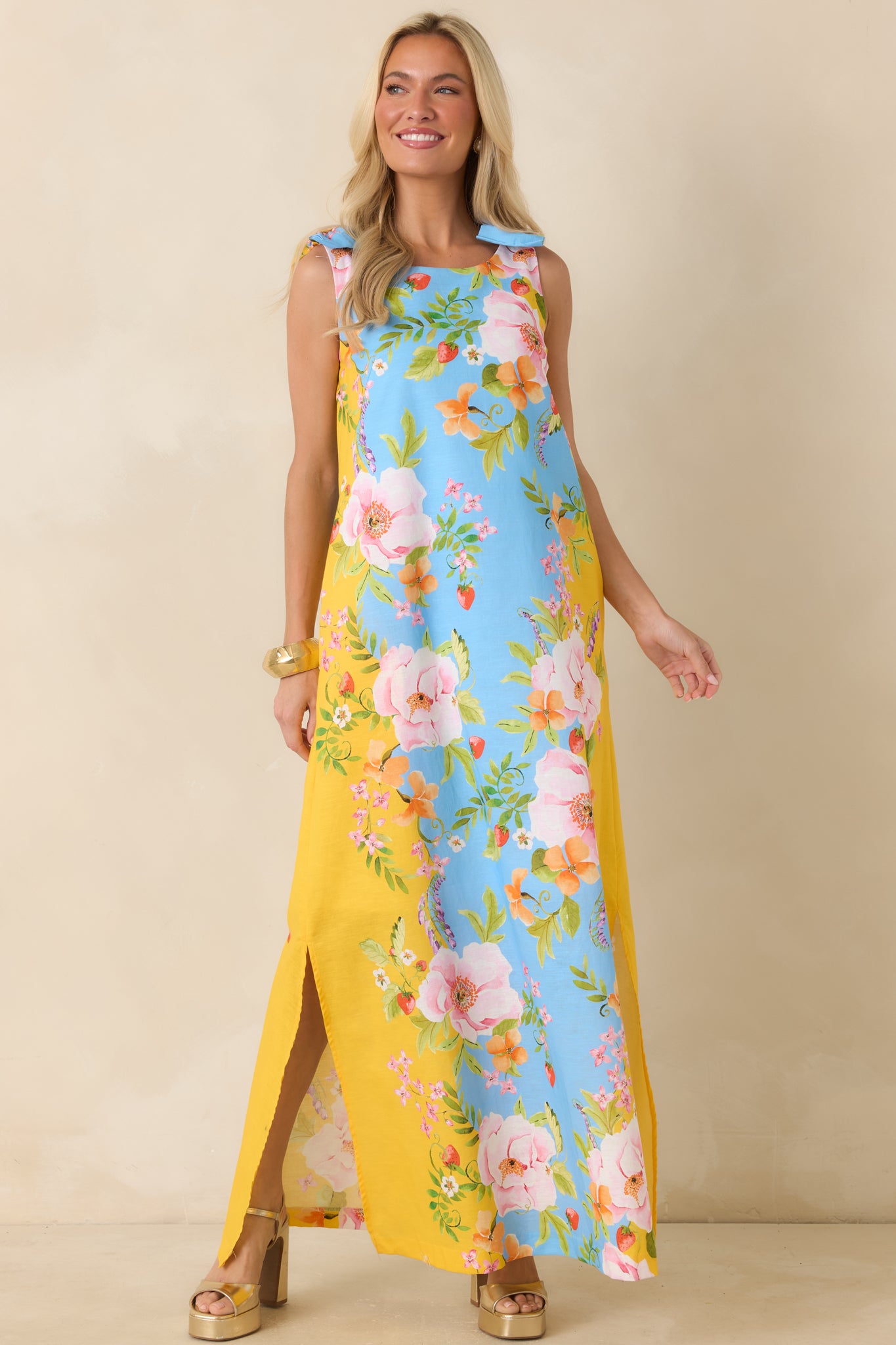 Vibrant floral maxi dress featuring a round neckline, side slits, and a lightweight draped design.