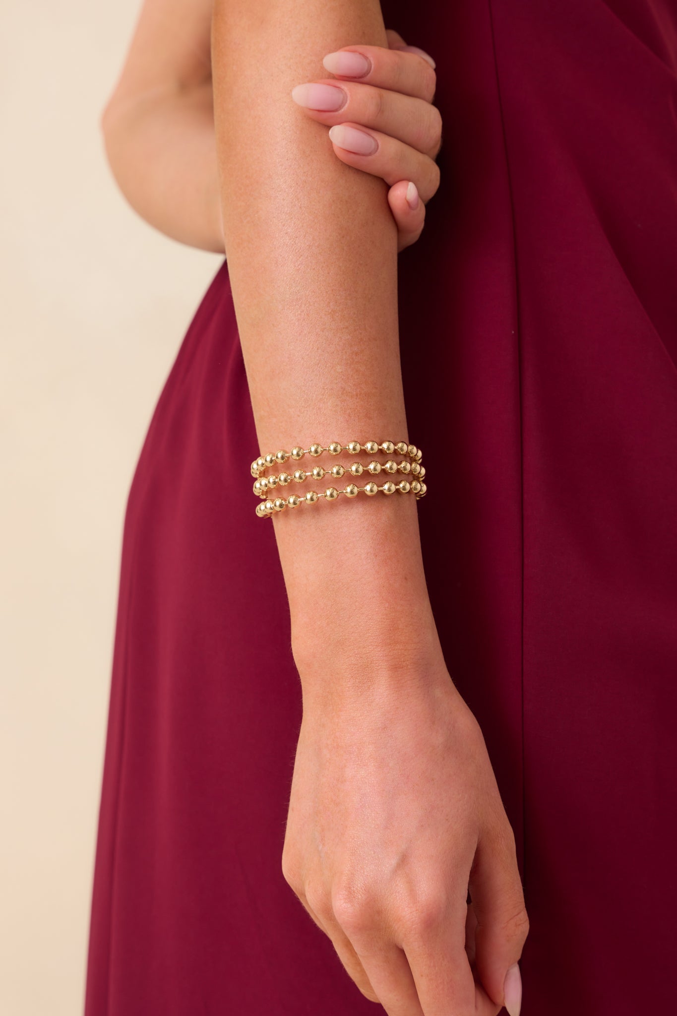 A close-up detail of the bracelet showing the textured ball prongs and polished gold surface.
