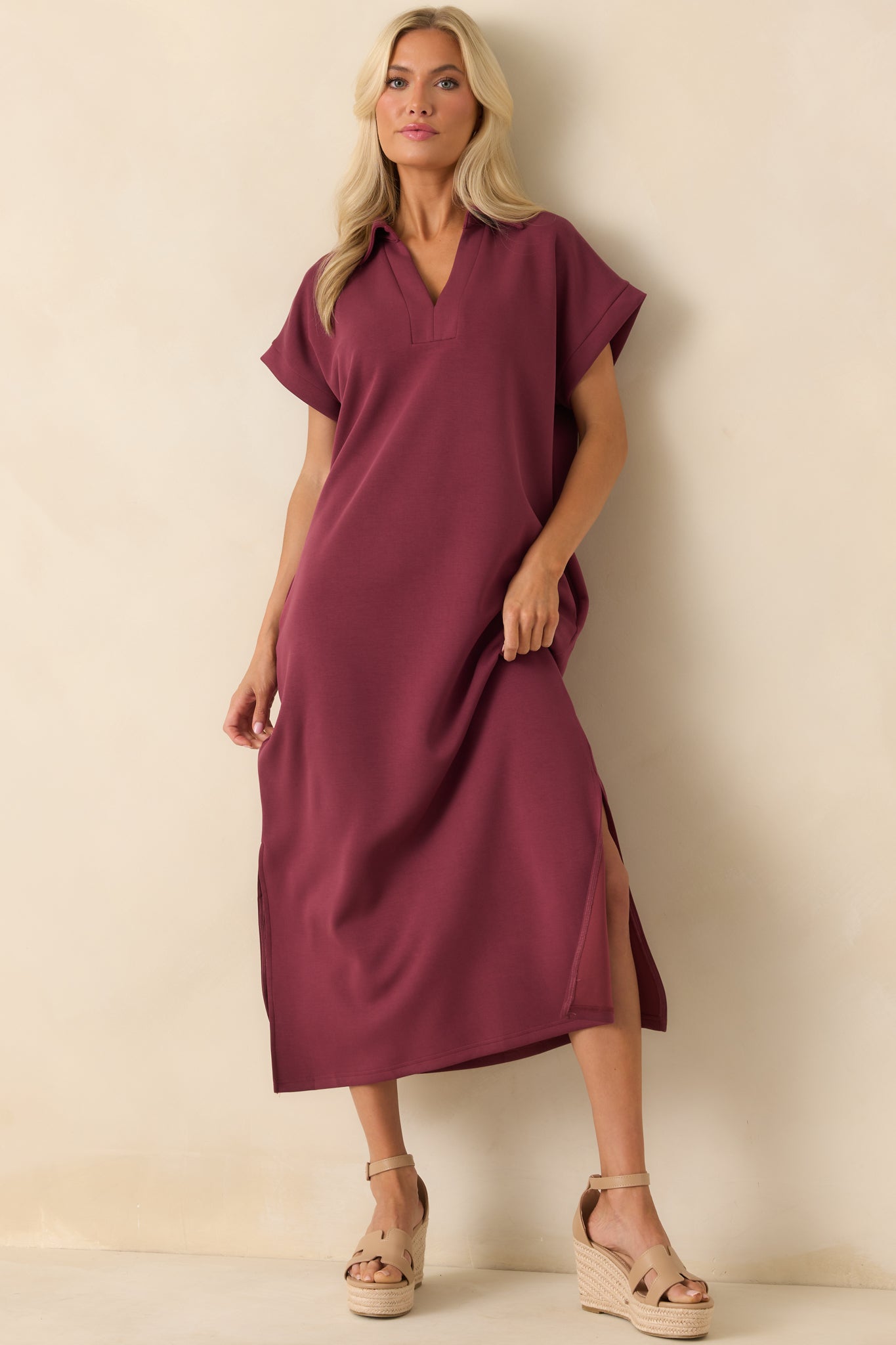 Front shot of buttery soft burgundy midi dress with notch v-neckline and side slits at the hem.