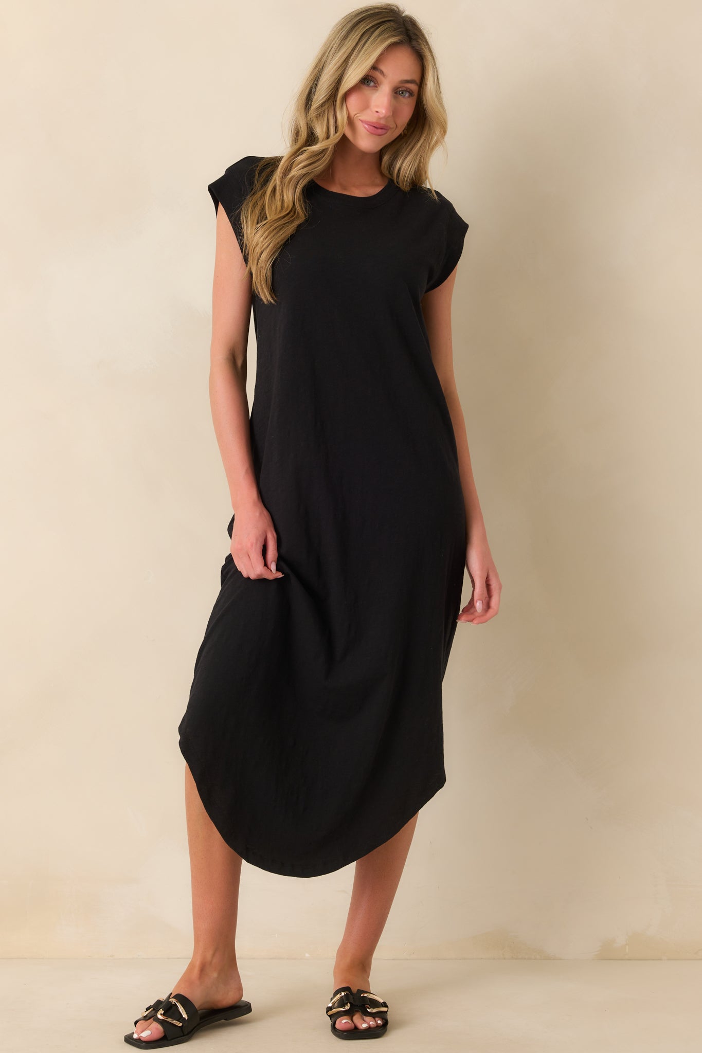 Front view of black dress highlighting smooth fabric, crew neckline. and simple silhouette.