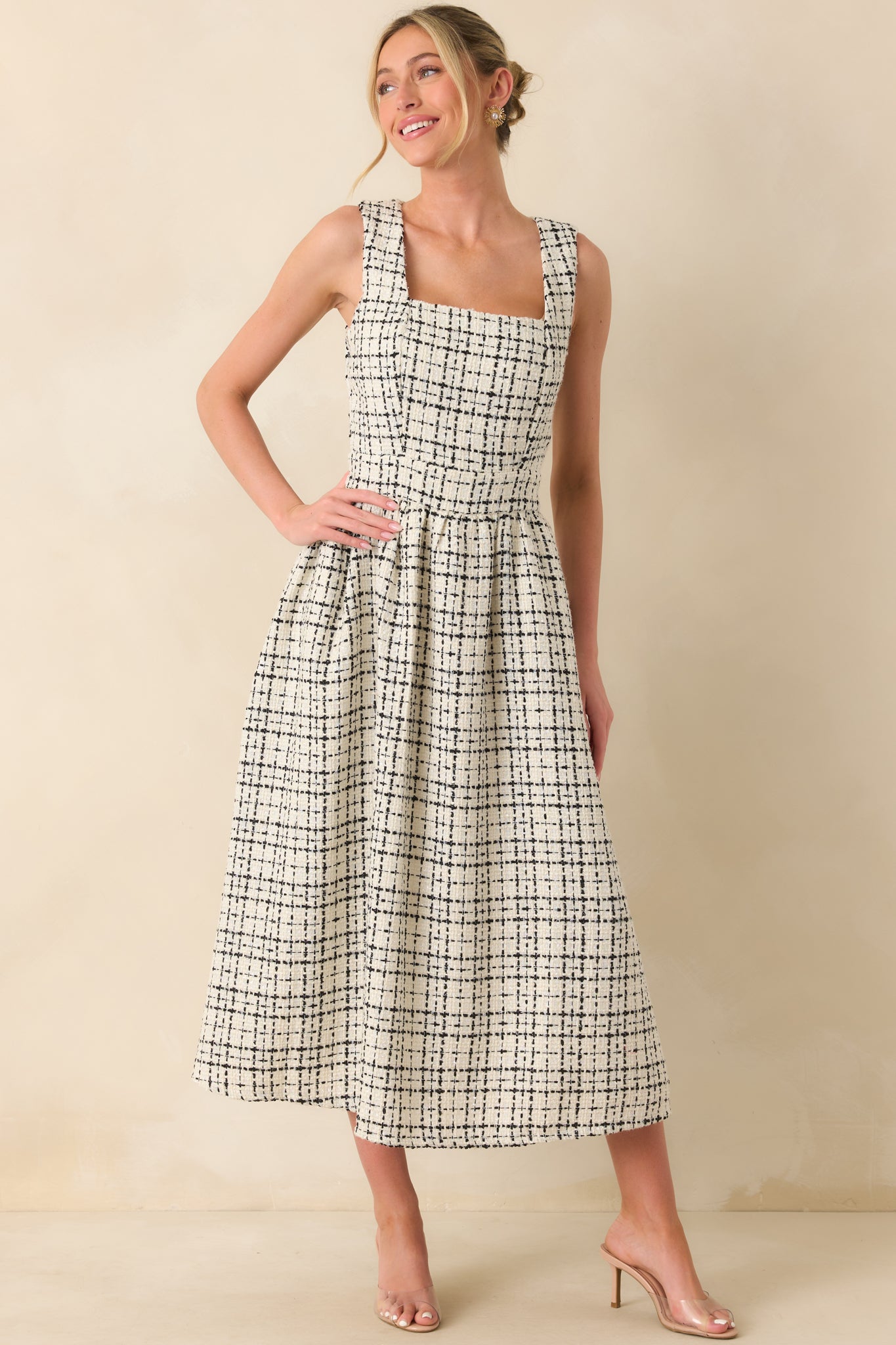 A front angle showing the sleeveless design and subtle texture of the tweed fabric.