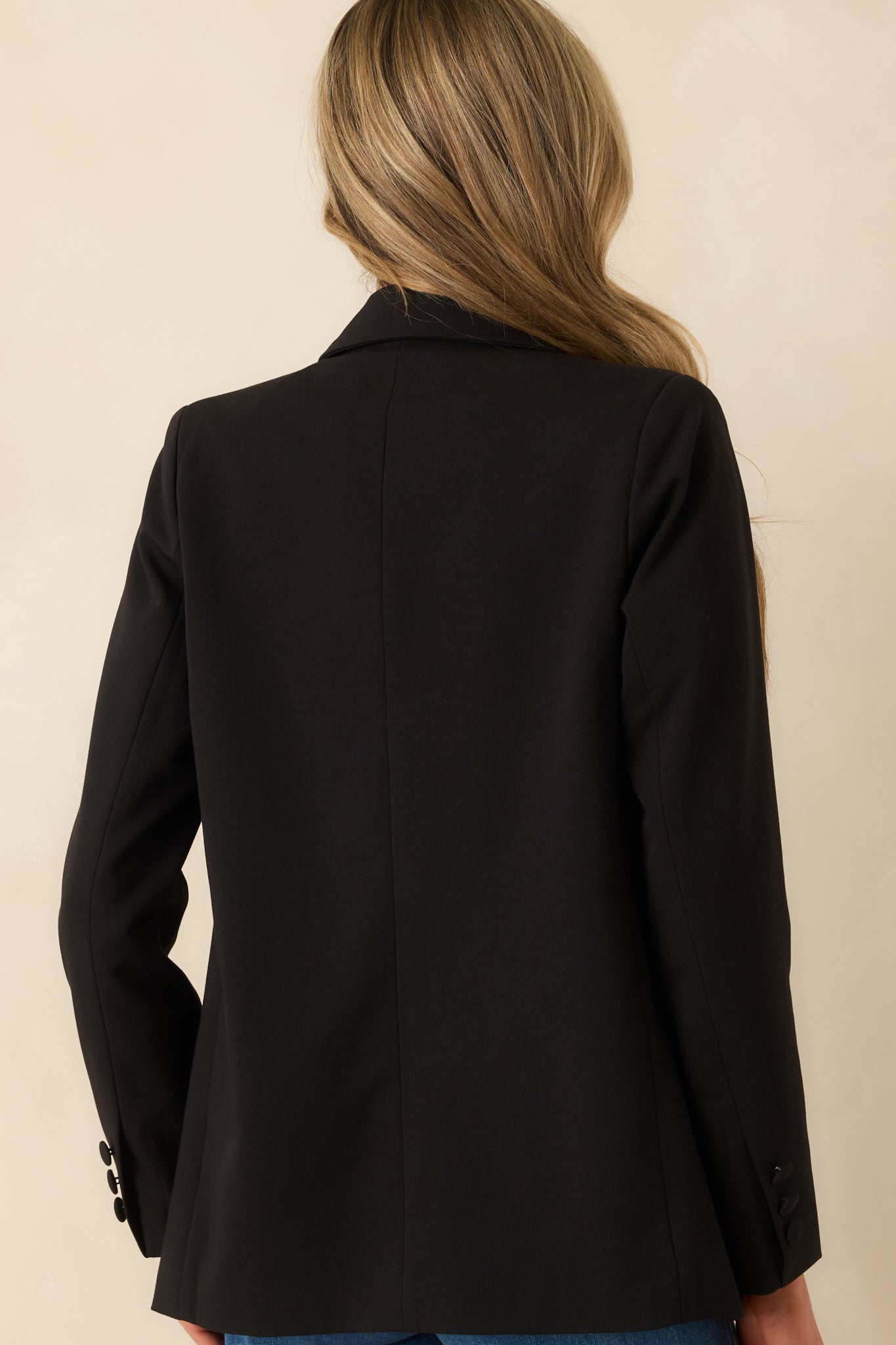 A back view of the blazer showing its tailored silhouette and clean finish across the back.