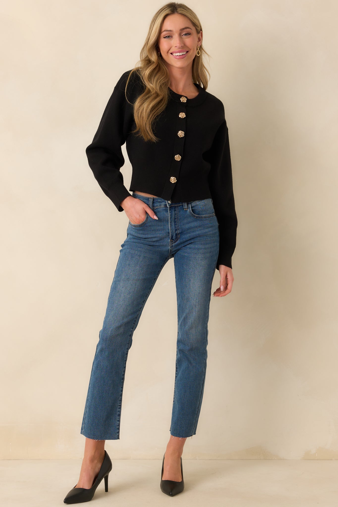 Standing pose displaying the cardigan fully buttoned, highlighting its fitted silhouette and structured ribbed hem.