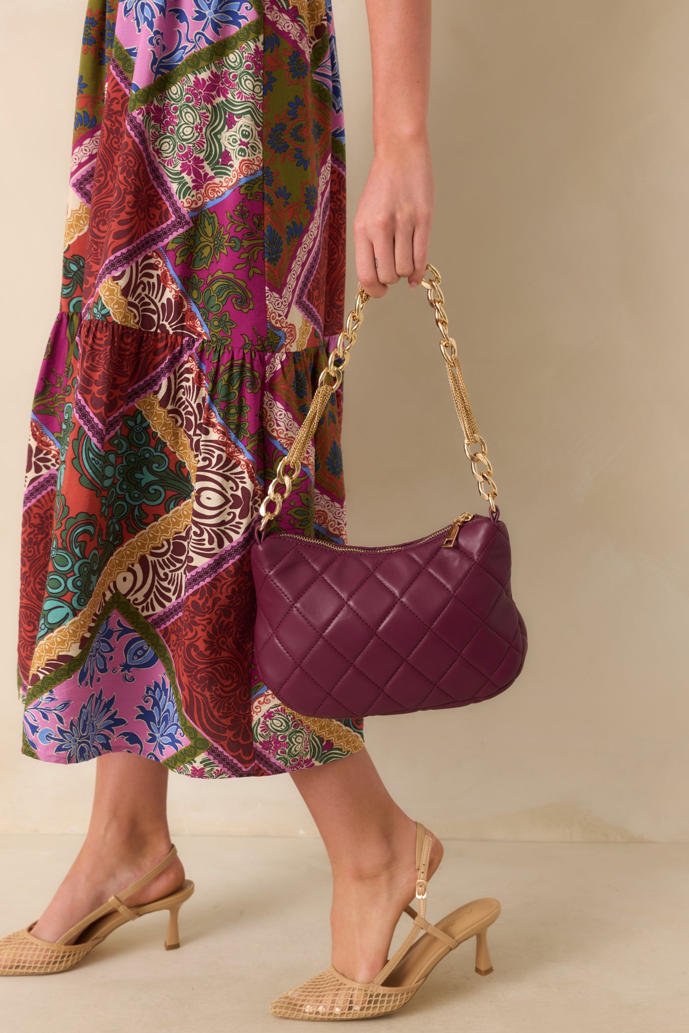 Merlot faux leather handbag with a quilted design and thick gold chain handle.