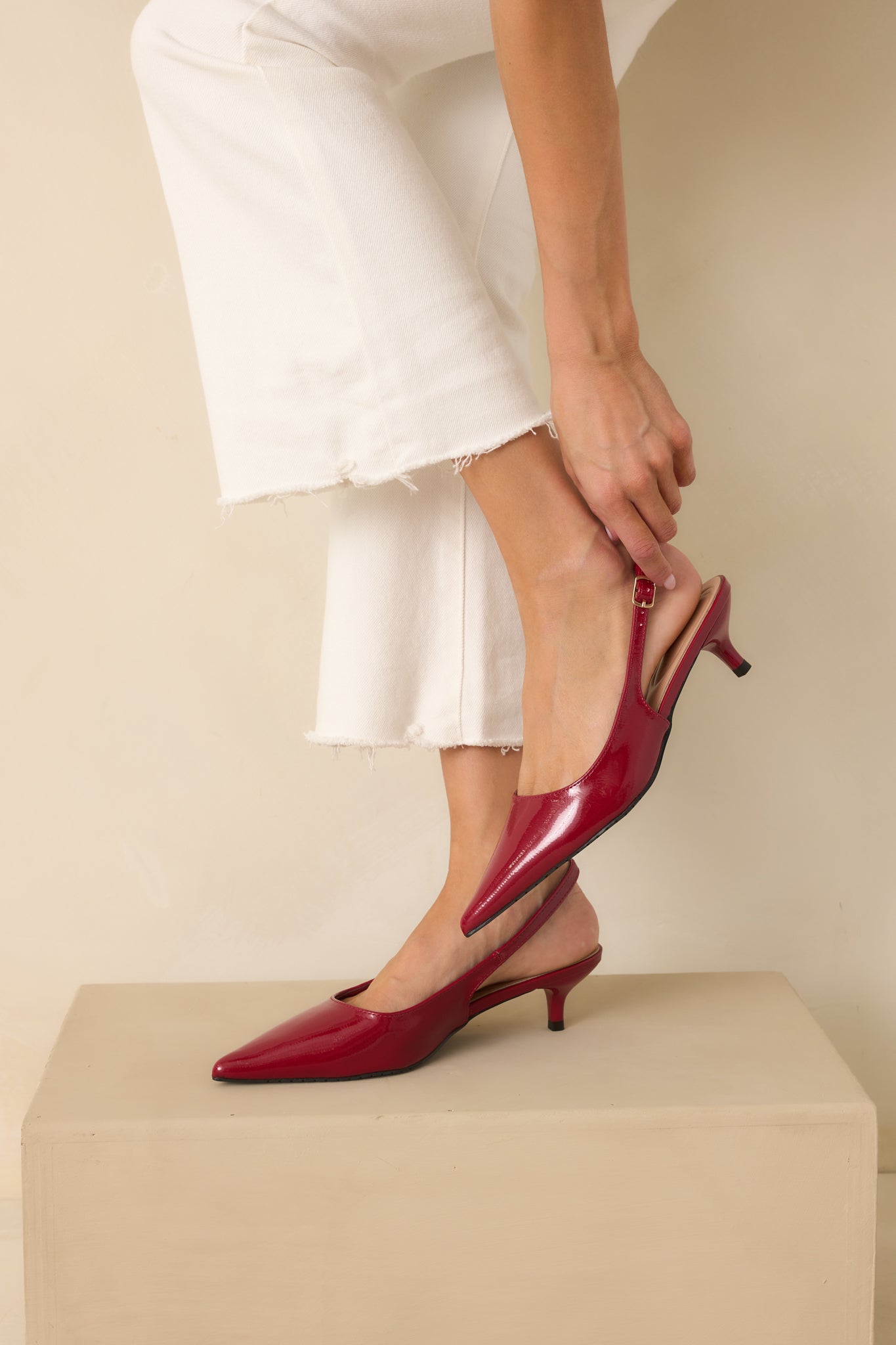 Red patent heels highlighting the pointed closed-toe and glossy finish.