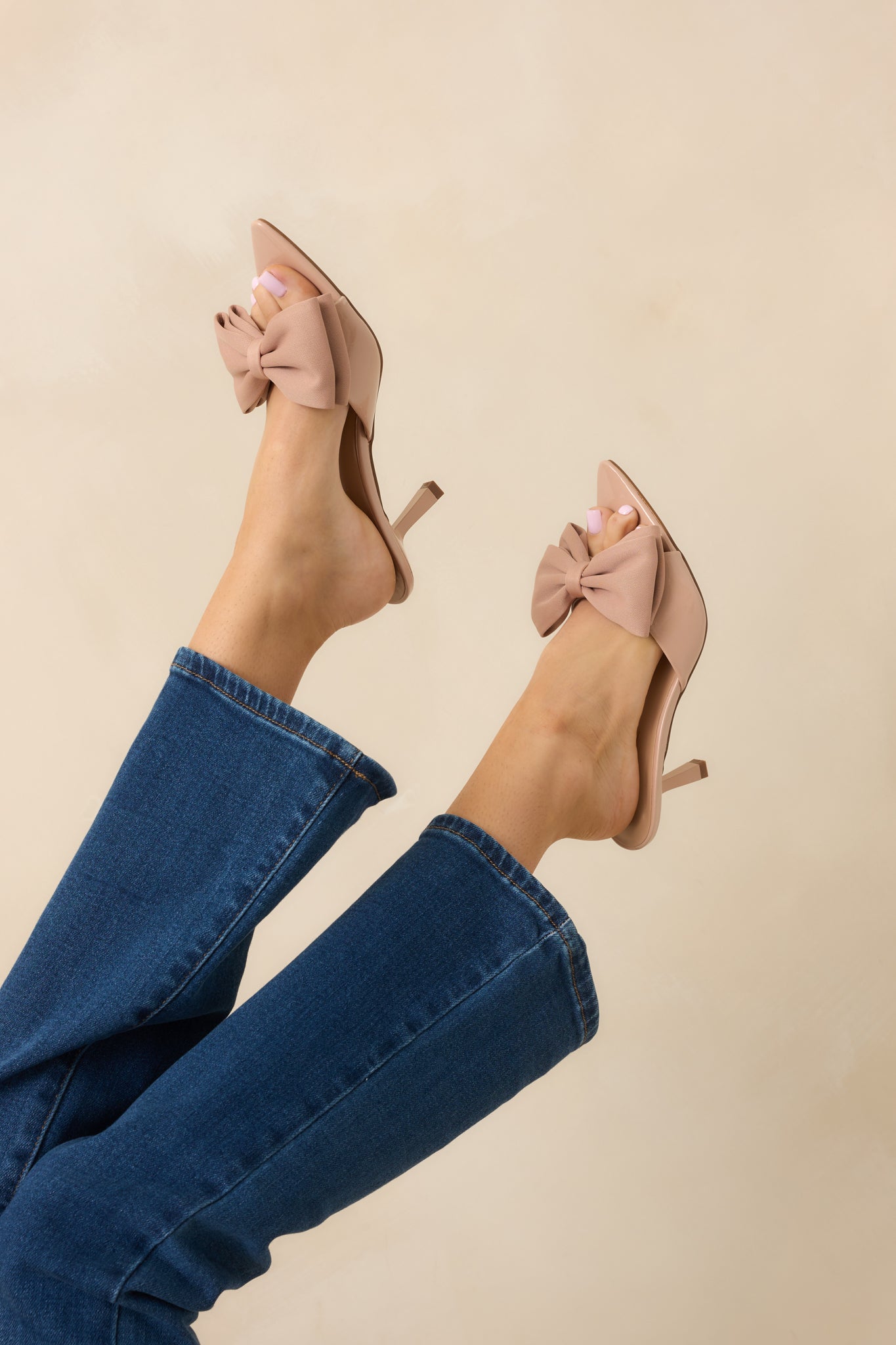 Focus on the bow detail and smooth neutral finish of the heel strap.