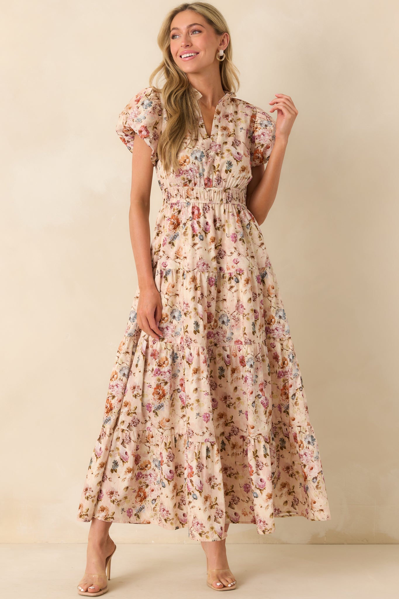 A full body front view of the light pink maxi dress showing the multicolor floral print and tiered skirt.