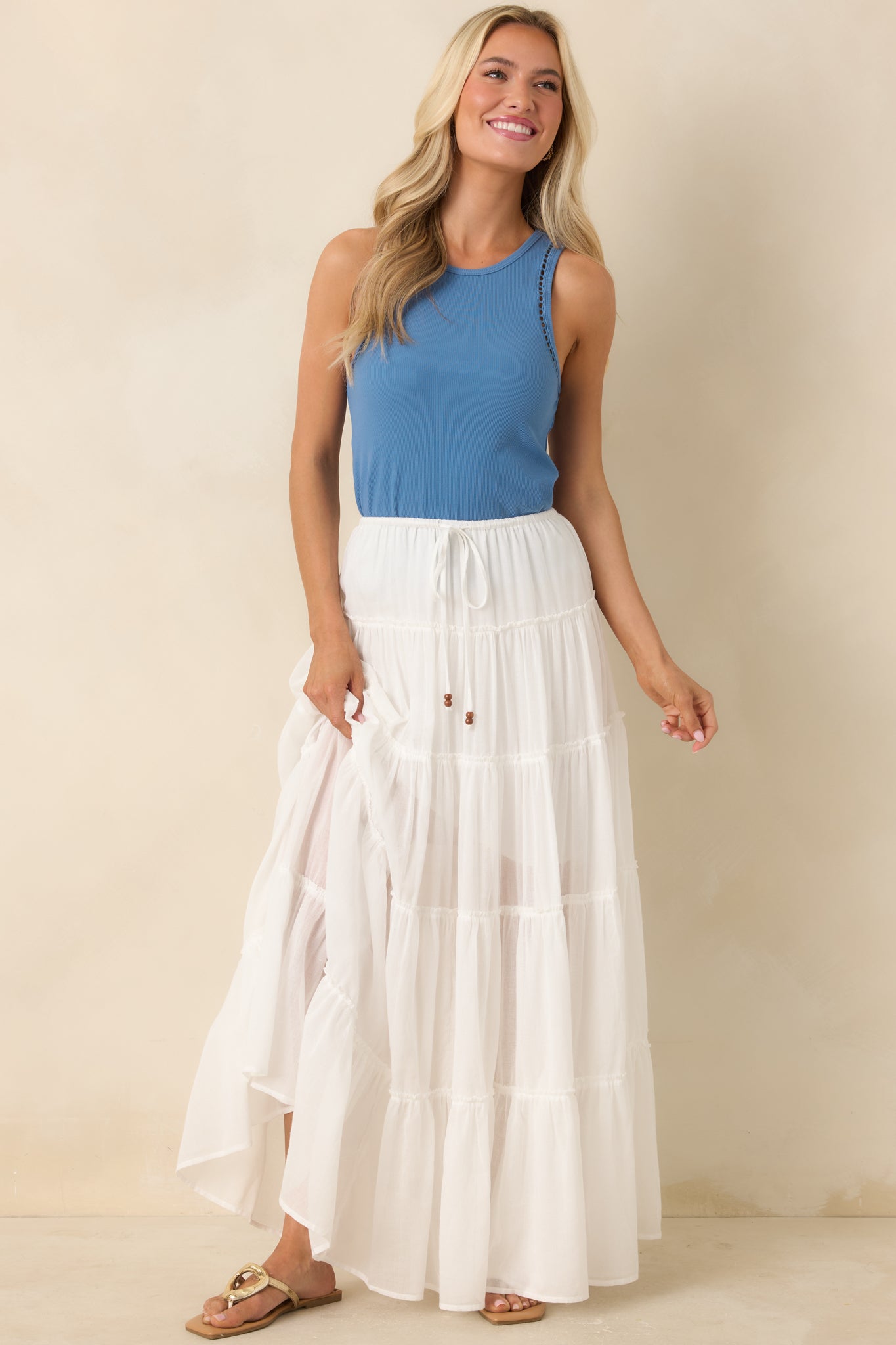 Flowing ivory skirt featuring multi-tiered design and relaxed drape.