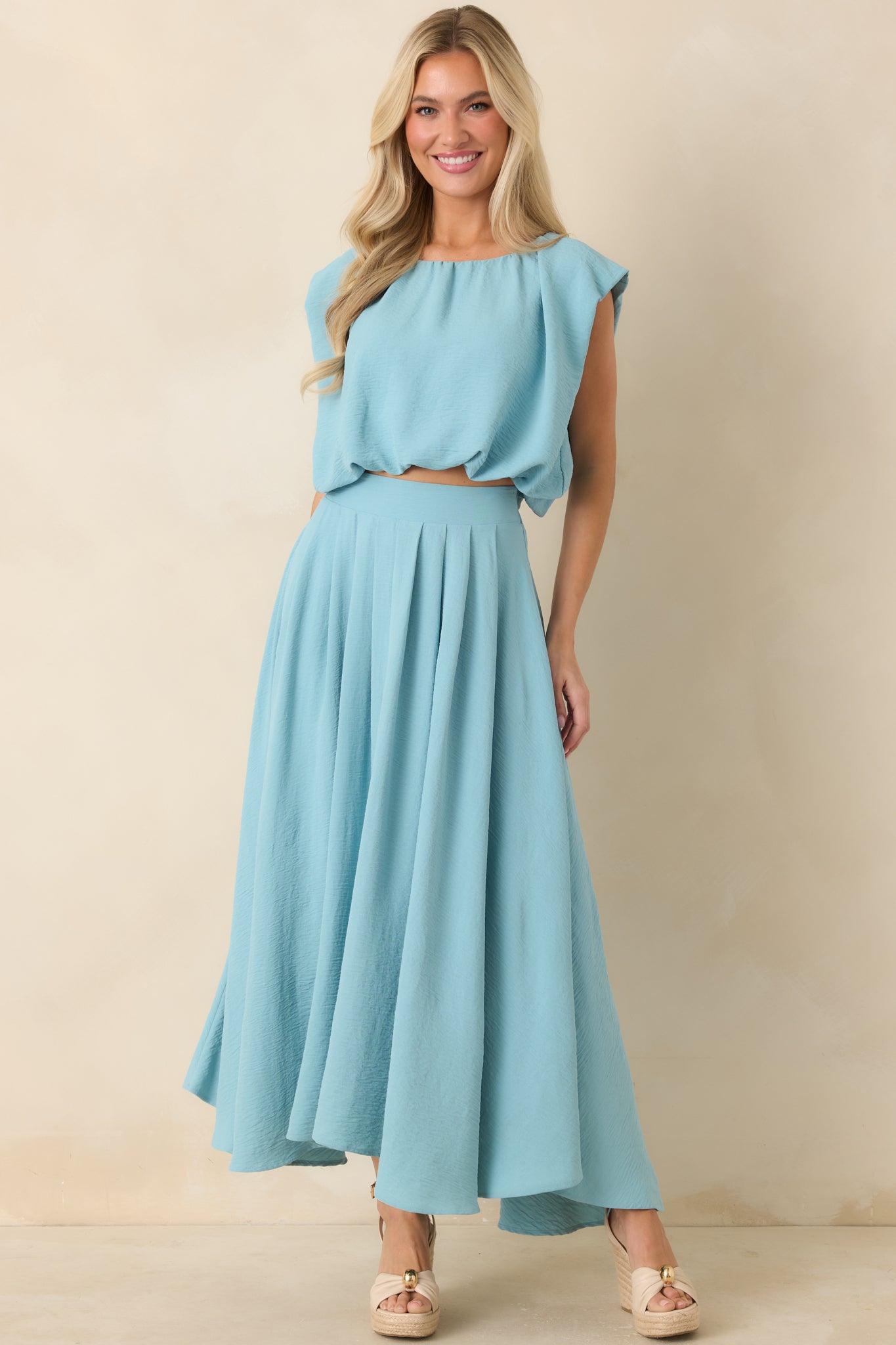 Turquoise sleeveless top featuring a gathered neckline, lightweight blouson fit, and cropped length.