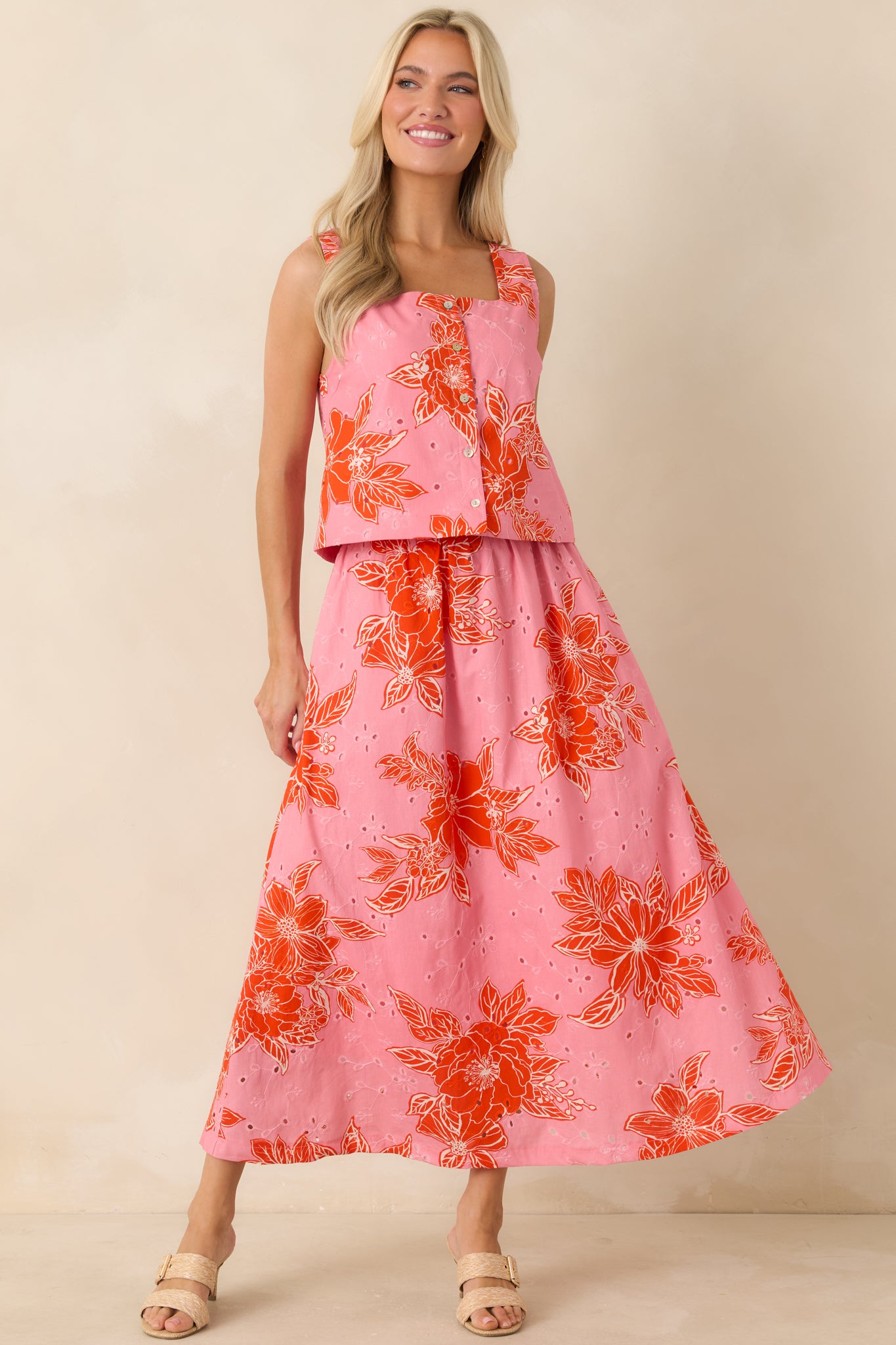 Floral sleeveless crop top with square neck, button closure, and soft cotton eyelet texture.