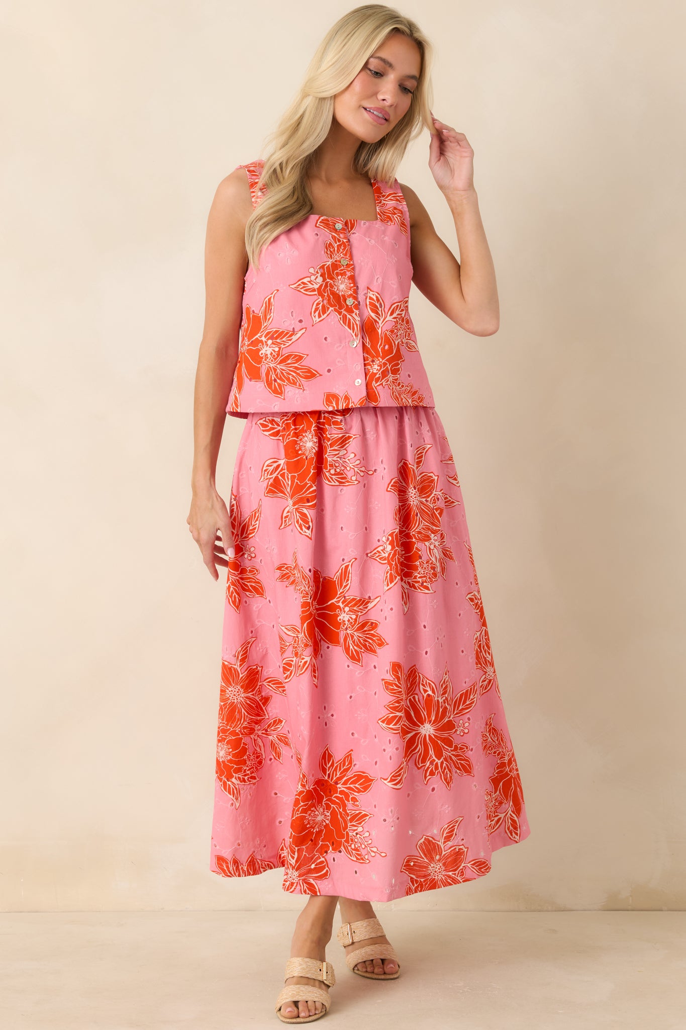 Bright floral crop top in pink and red with cropped silhouette and breathable eyelet fabric.