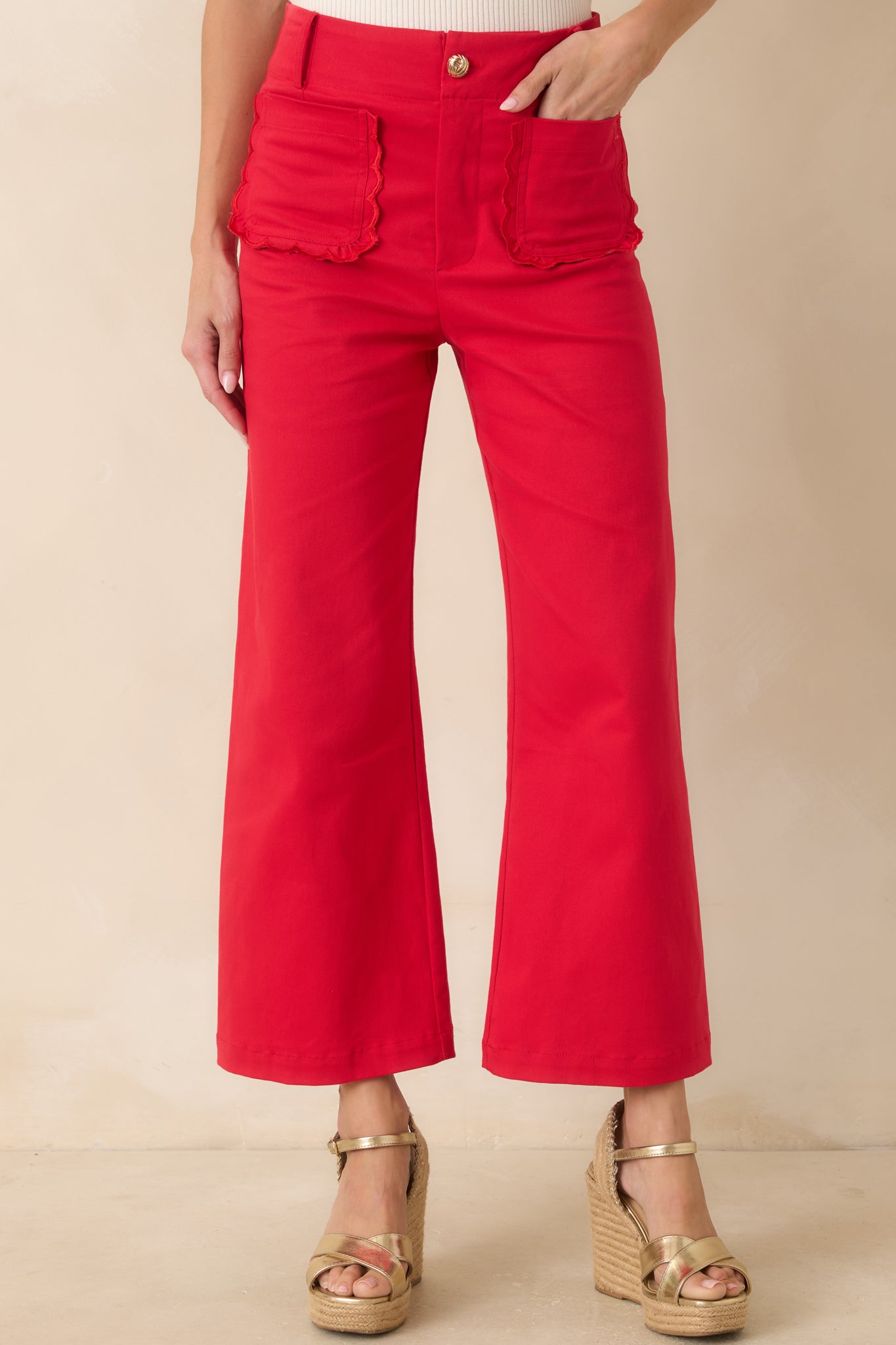 Detailed look at the oversized scalloped front patch pocket design in the bold red cotton fabric.