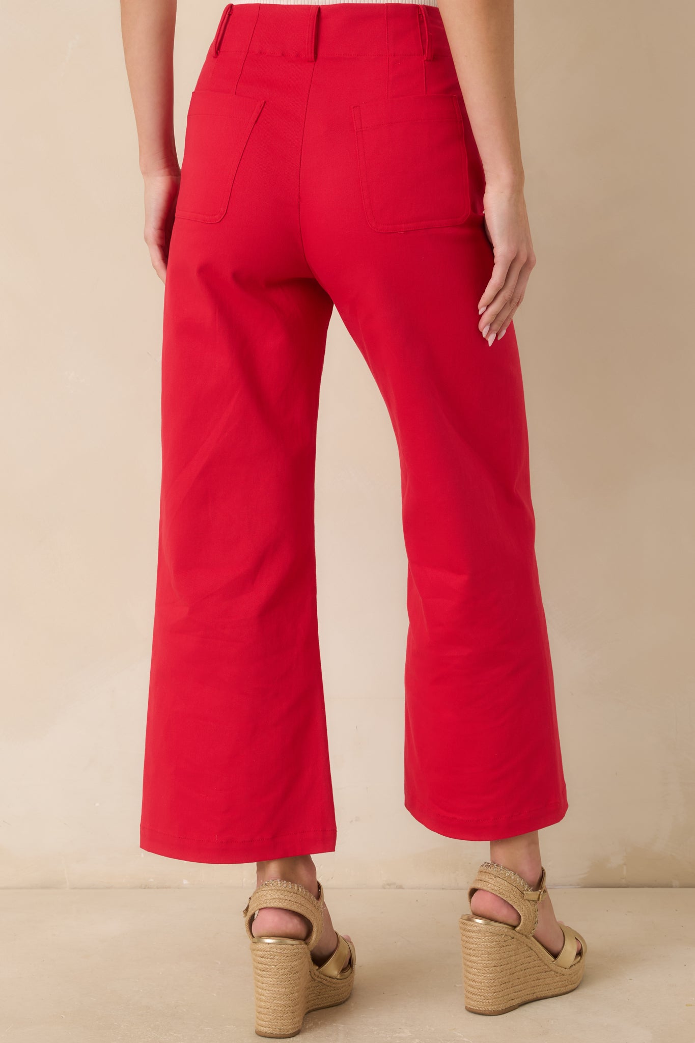 Back view of the cherry red pants featuring functional back pockets and a clean high-rise wide-leg silhouette.