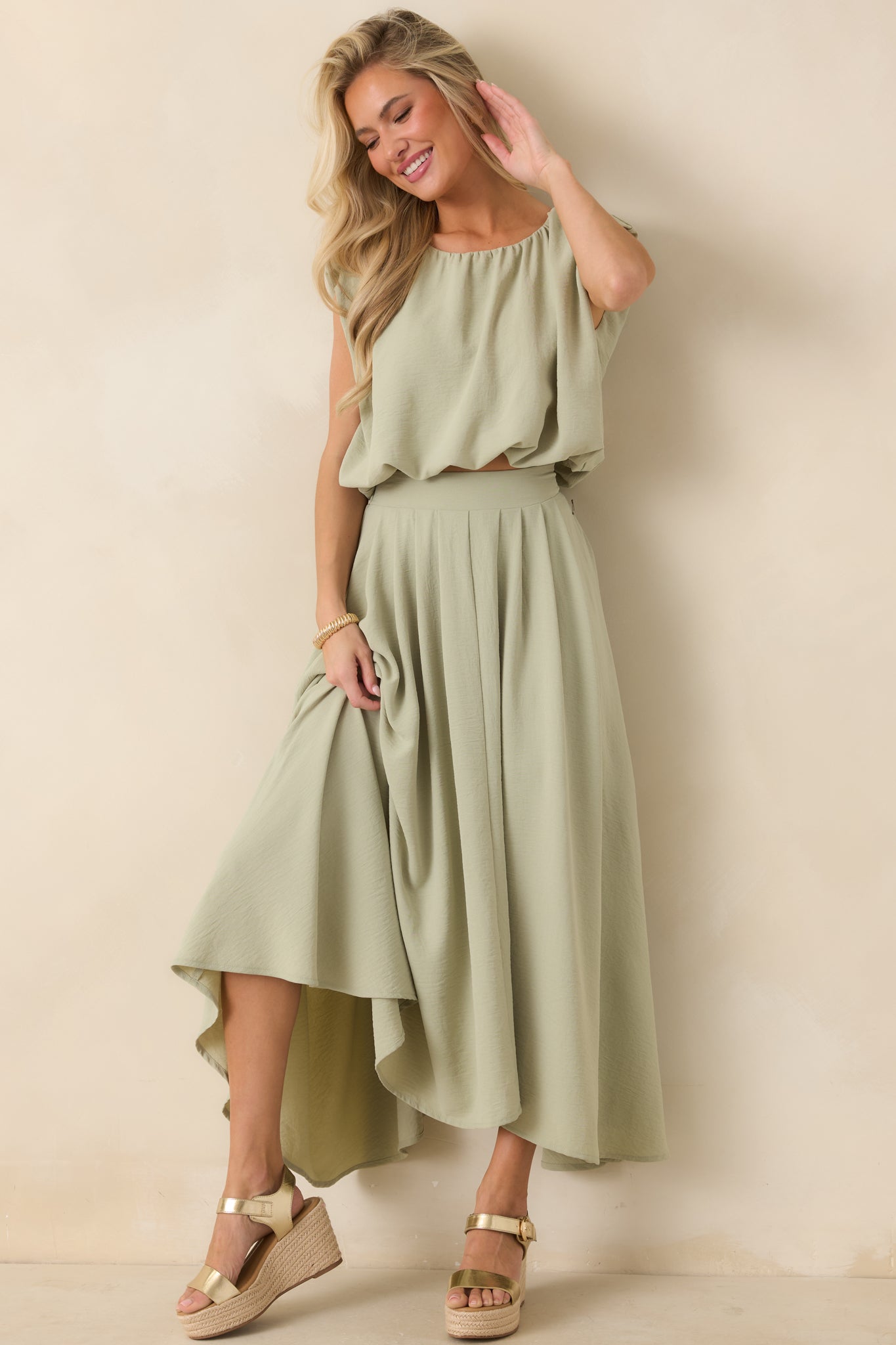 Sage green cropped top with blouson silhouette, gathered neckline, and sleeveless design.
