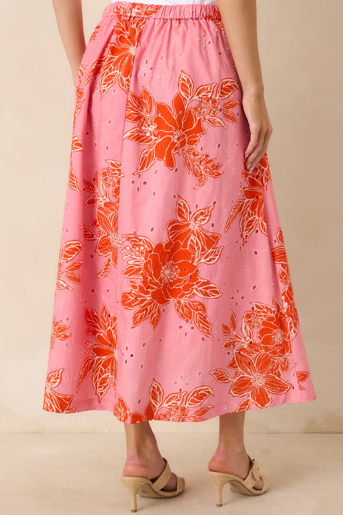 Rear view of floral midi skirt with elastic waistband and flowing eyelet fabric.