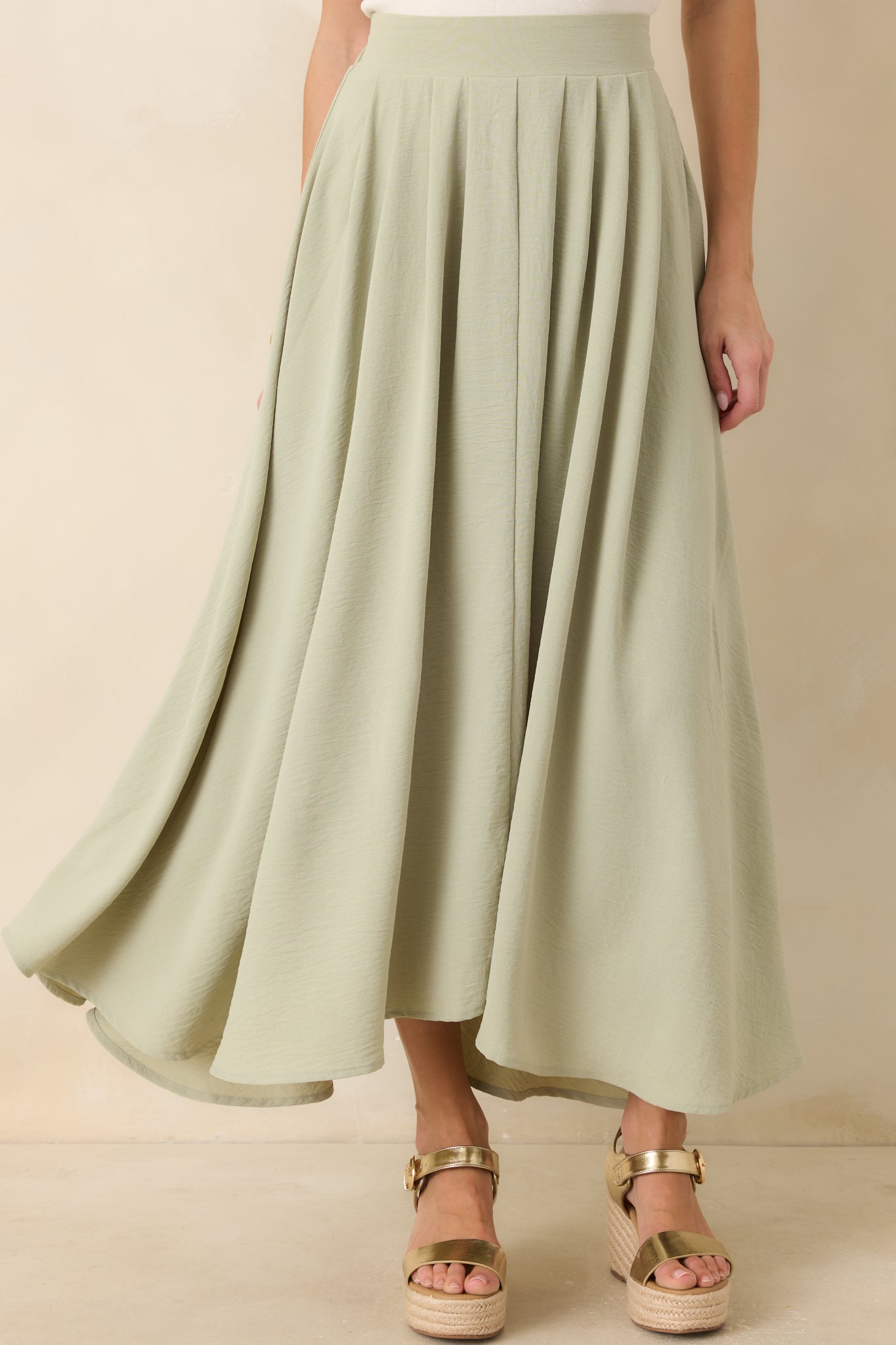 Close view of sage green fabric revealing smooth lining and lightweight texture.