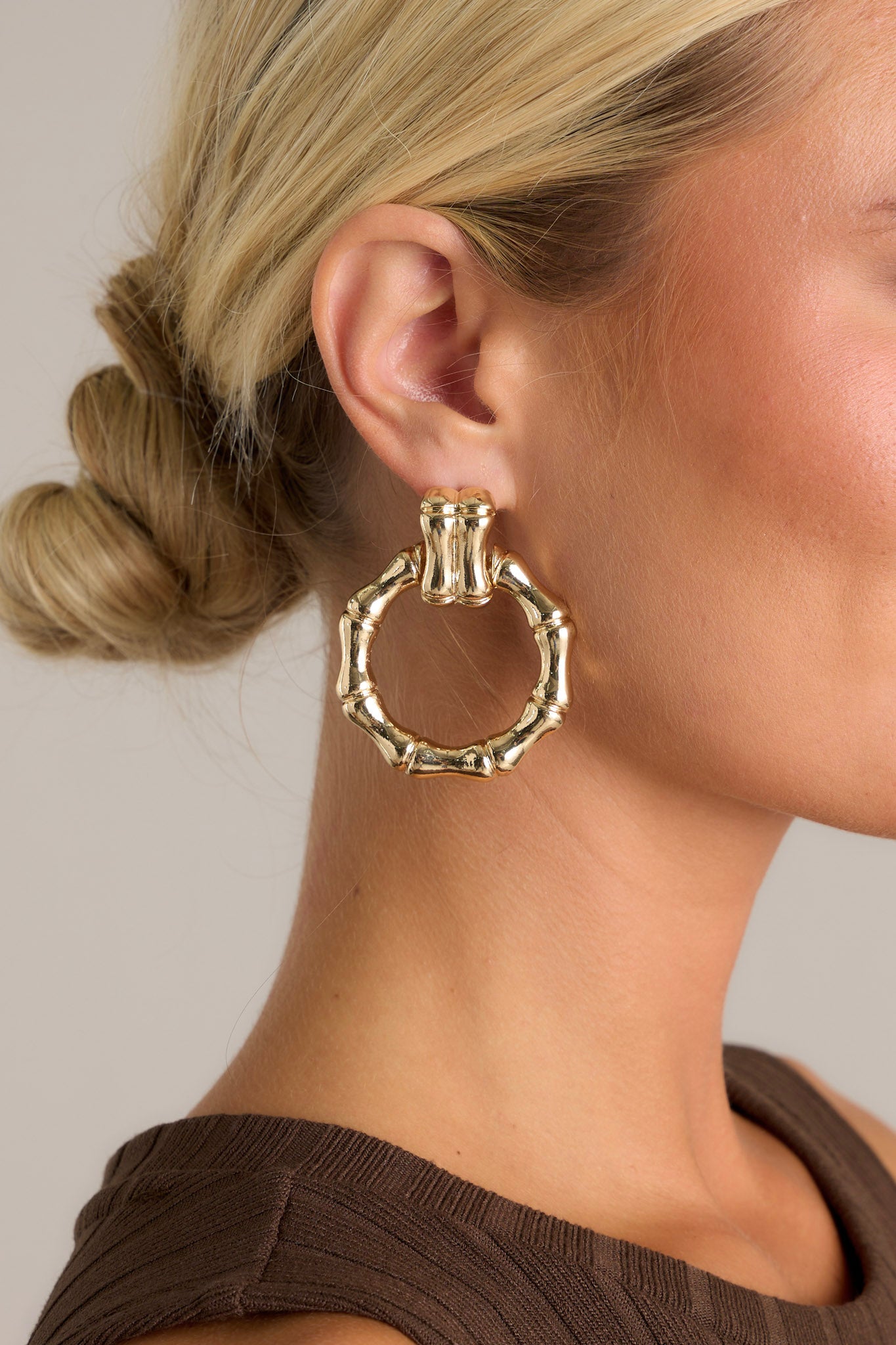 These gold earrings feature textured gold hardware, a textured stud with a connected textured hoop, and secure post backings.
