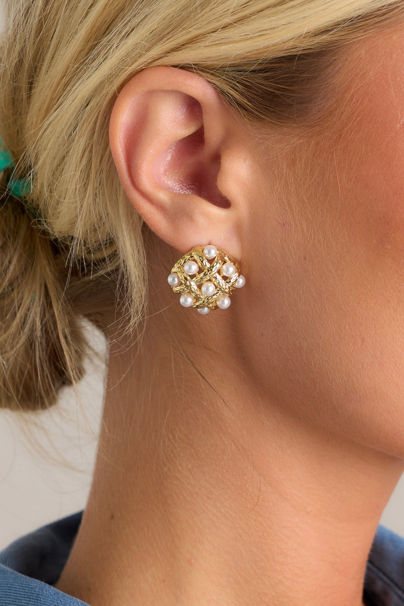 Detail of the gold earrings showing both the woven pattern and secure post backings
